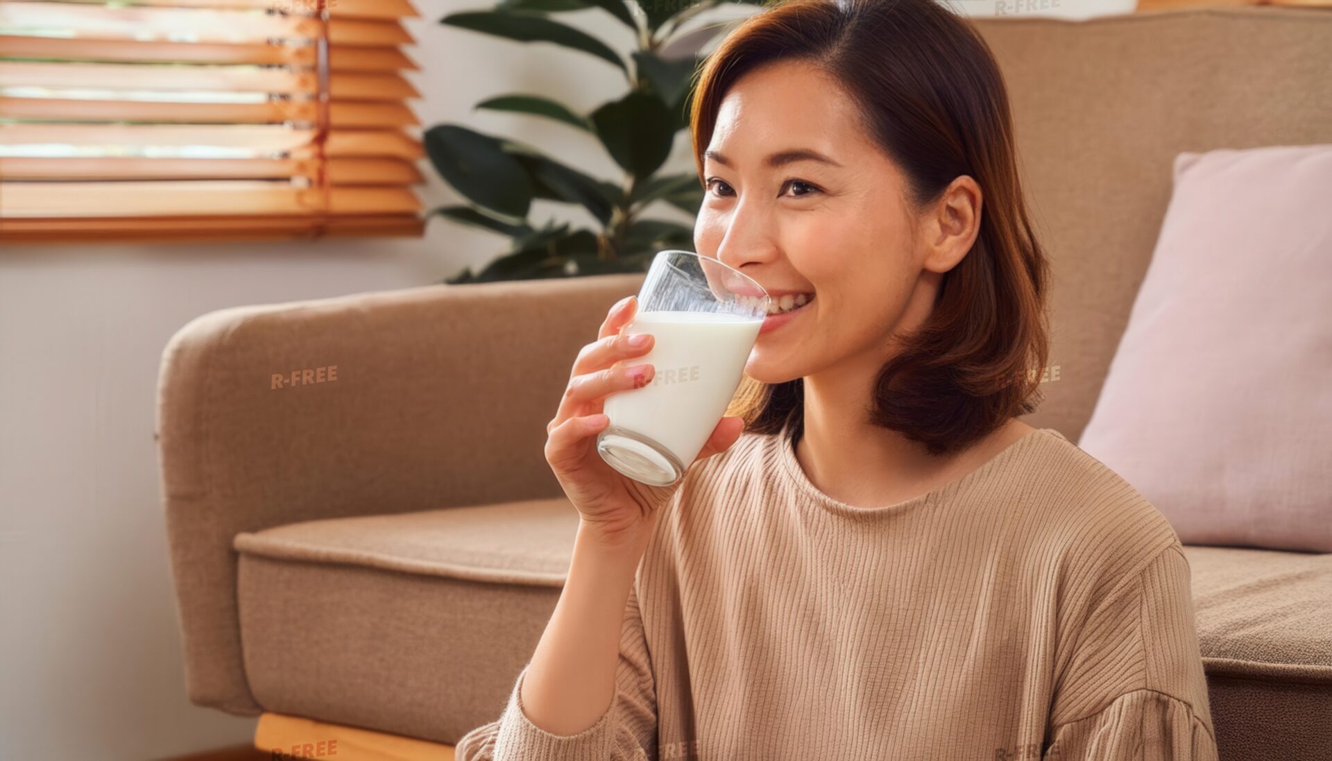 室内で牛乳を飲むベージュの服の大人