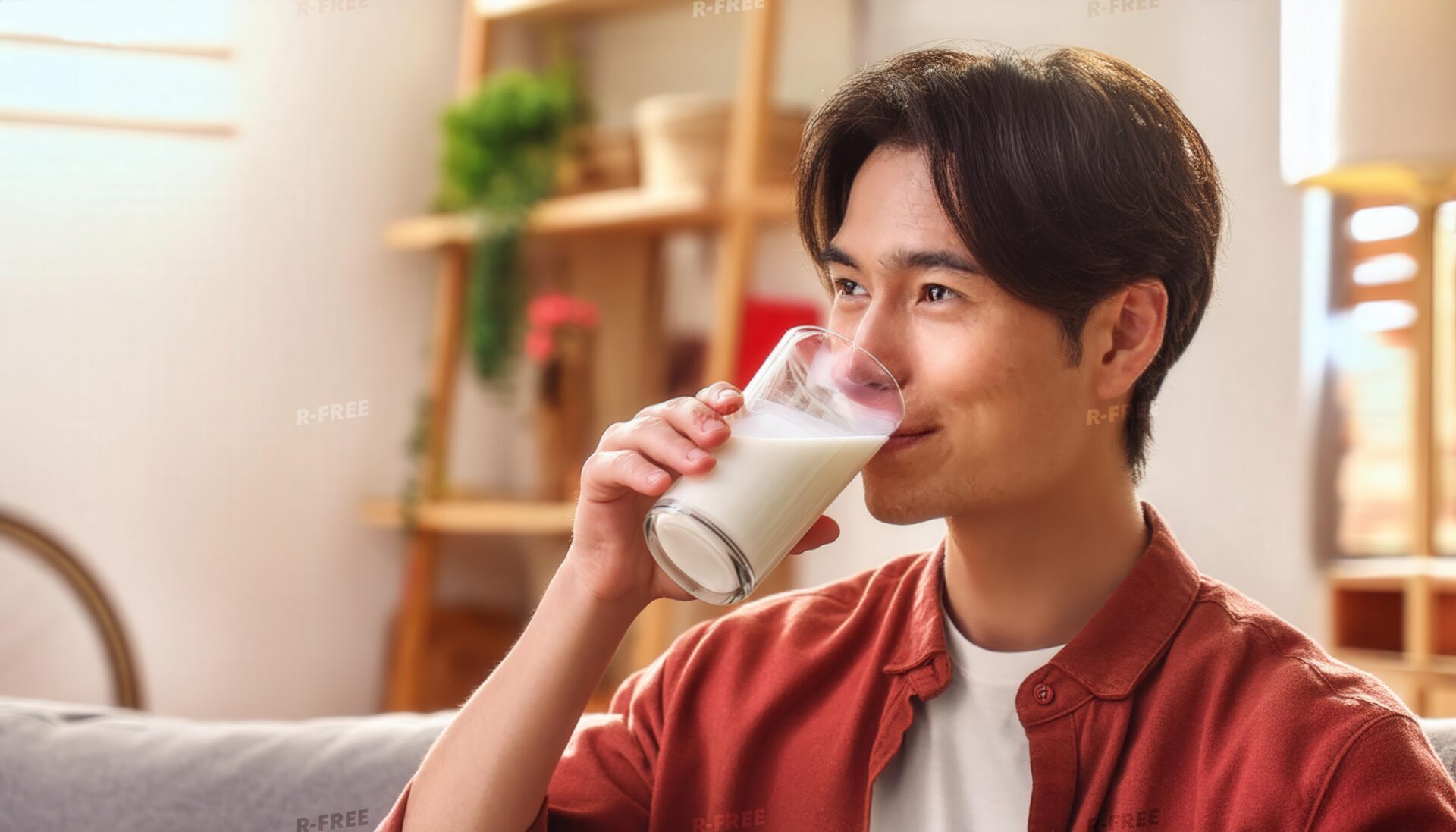 室内で牛乳を飲む赤い服の大人