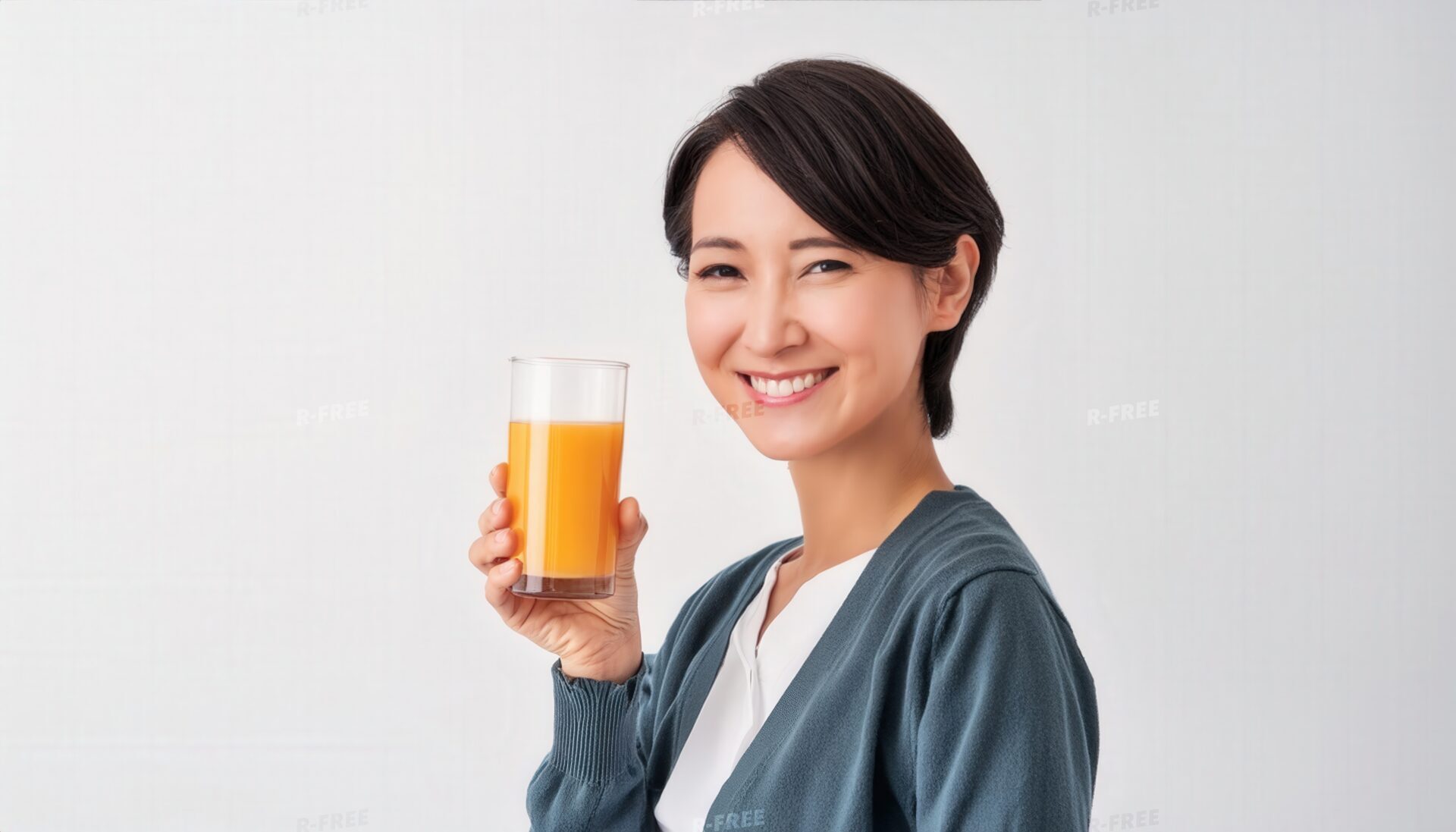 笑顔でオレンジジュースを持つ短い黒髪の若い女性