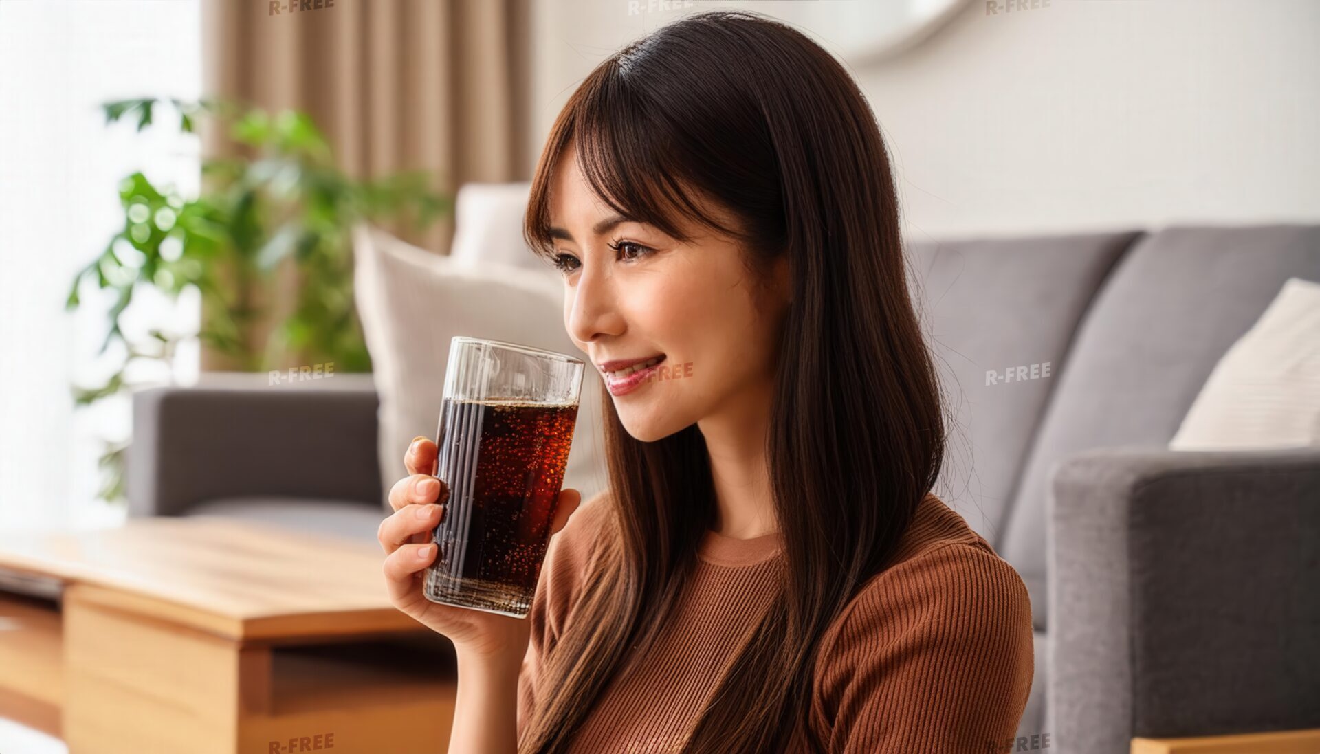 リビングで黒い炭酸飲料を持つ人