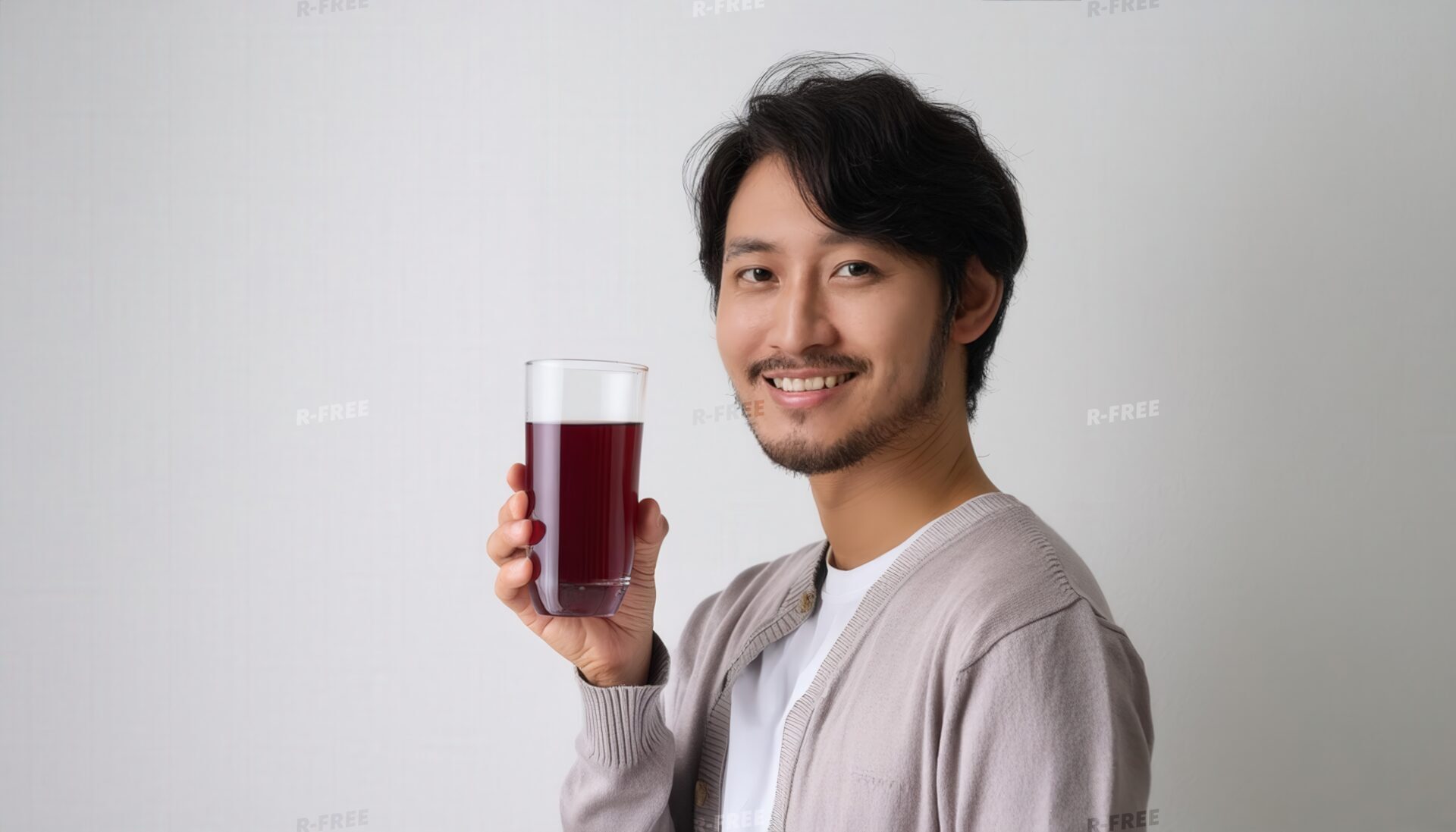 笑顔でグレープジュースを手に持つ白Tシャツの男性