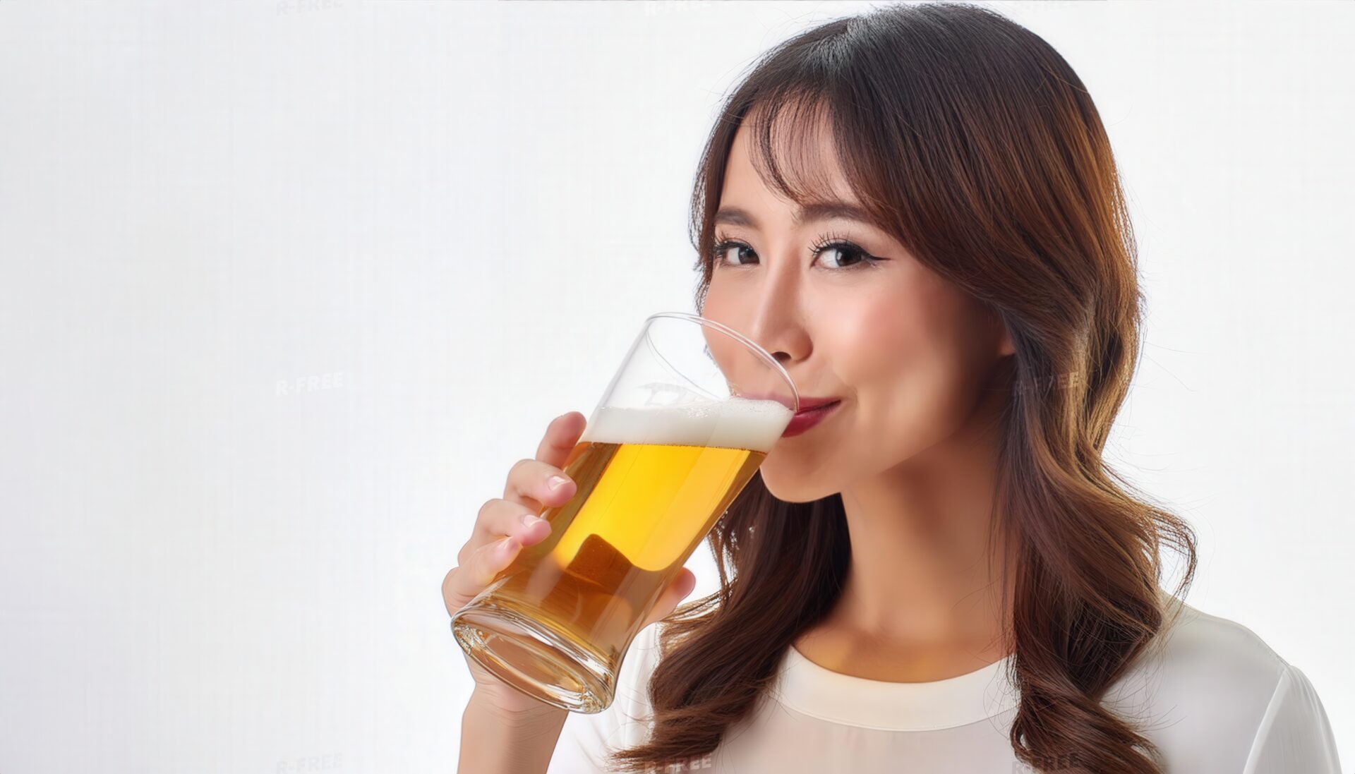 白いトップスで笑顔でビールを飲むロングヘアの女性