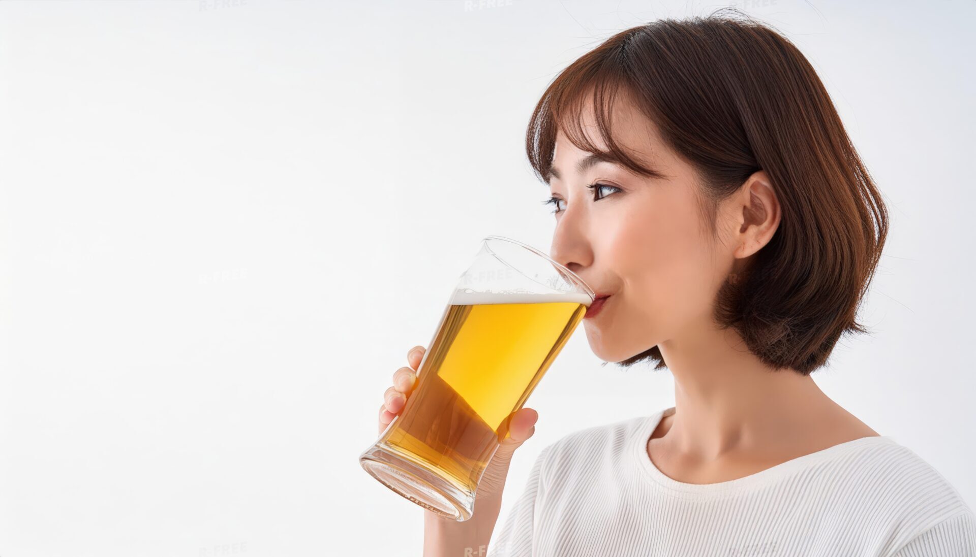 横顔でビールを飲む短い茶髪の白い服の女性