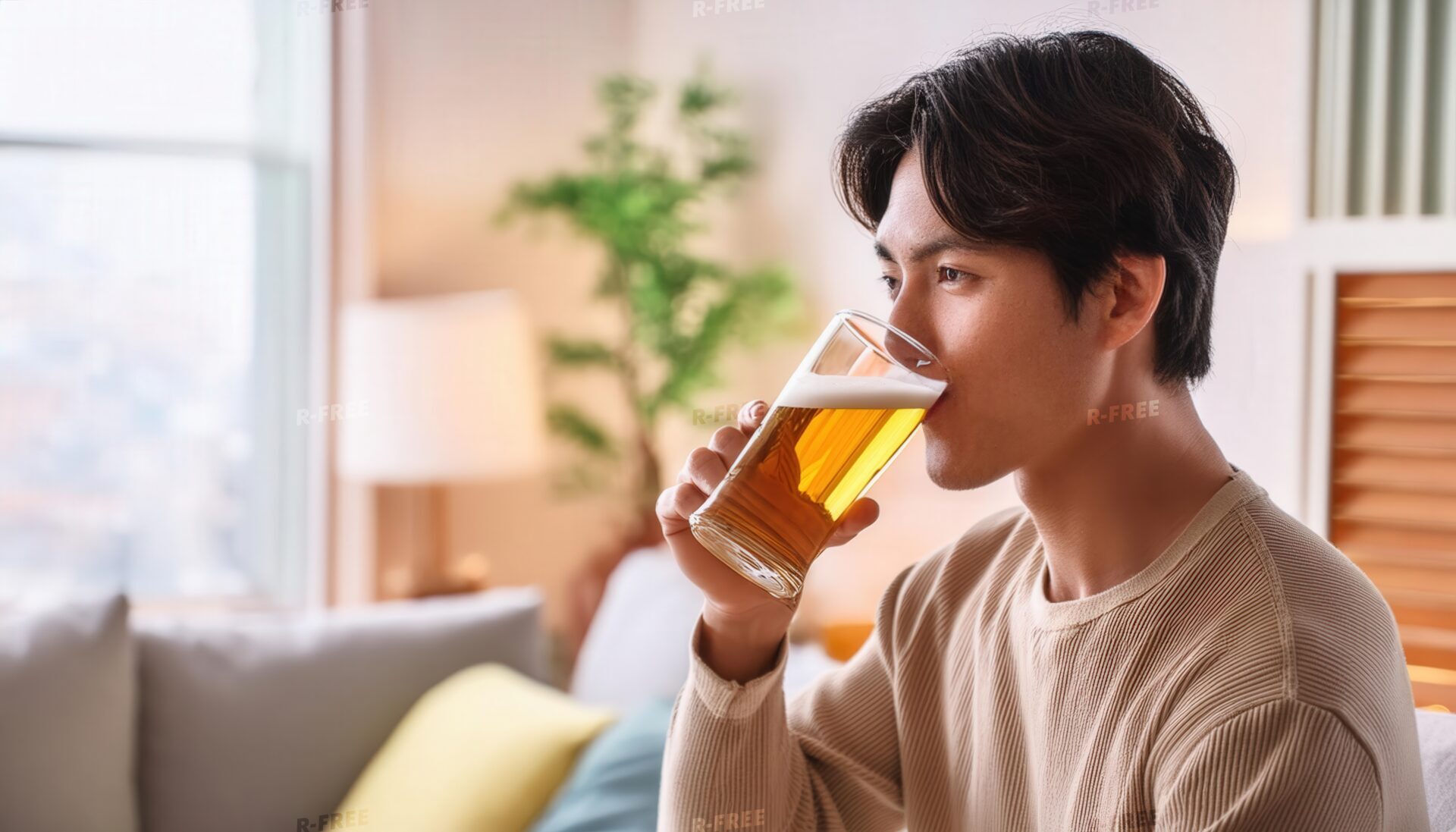 室内でビールを飲む若い男性