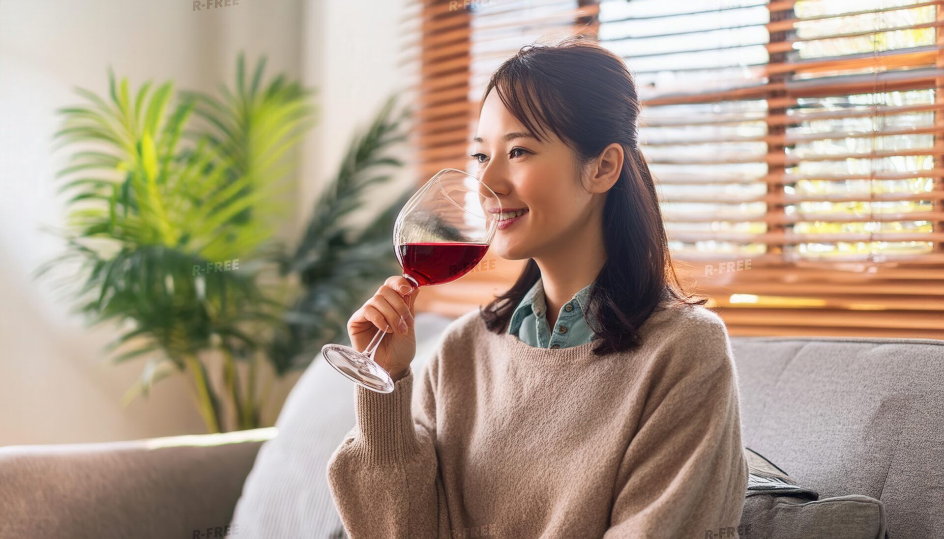 室内で赤ワインを楽しむ若い女性