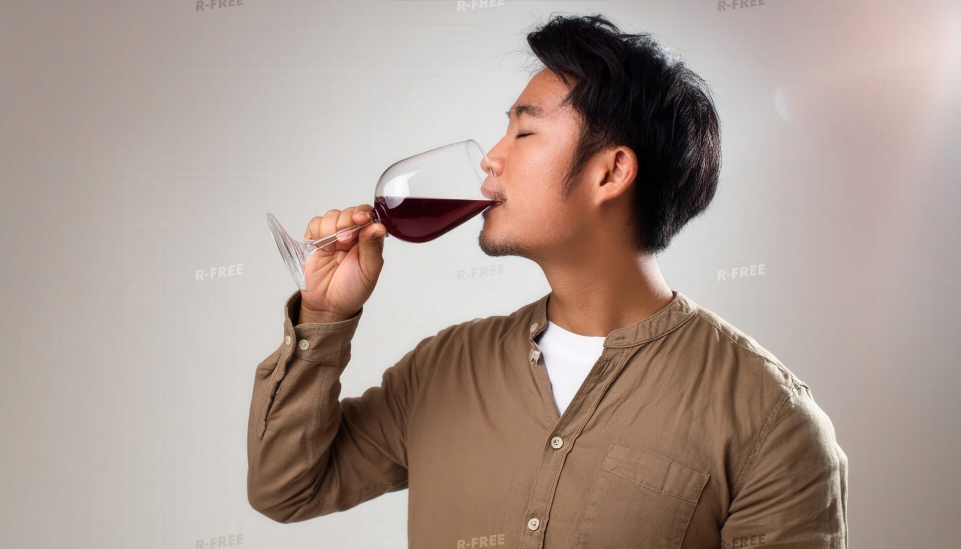 室内で赤ワインを飲む若い男性