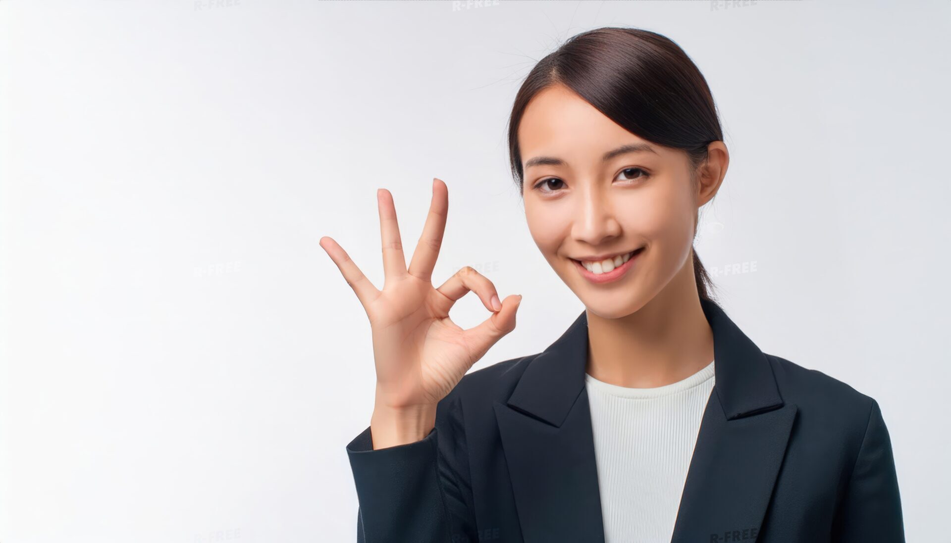 白背景で右手にOKサインを示す笑顔の女性