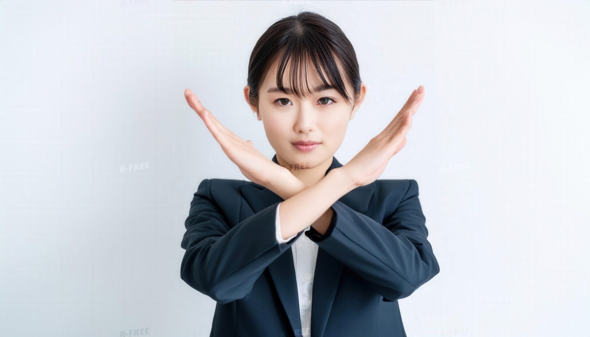 白背景でバツ印を示すビジネススタイルの女性
