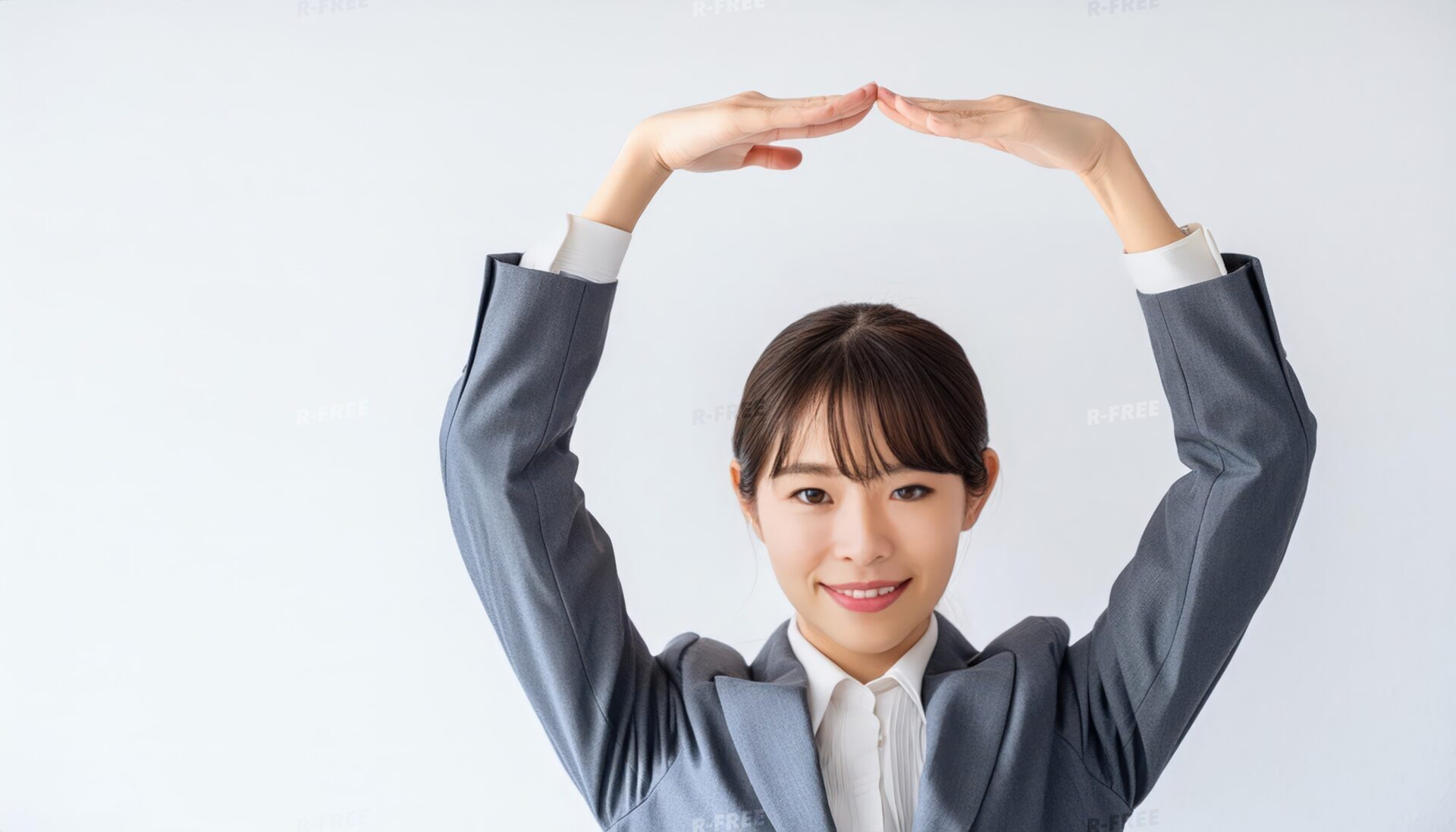 グレーのスーツで頭上に円を作っている若い人