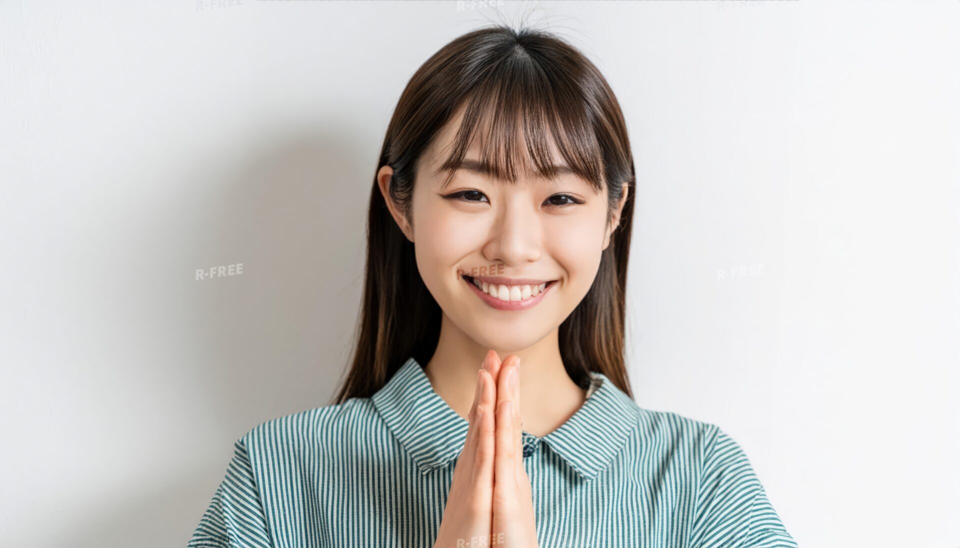 合掌する縦縞シャツの若い女性と長い黒髪