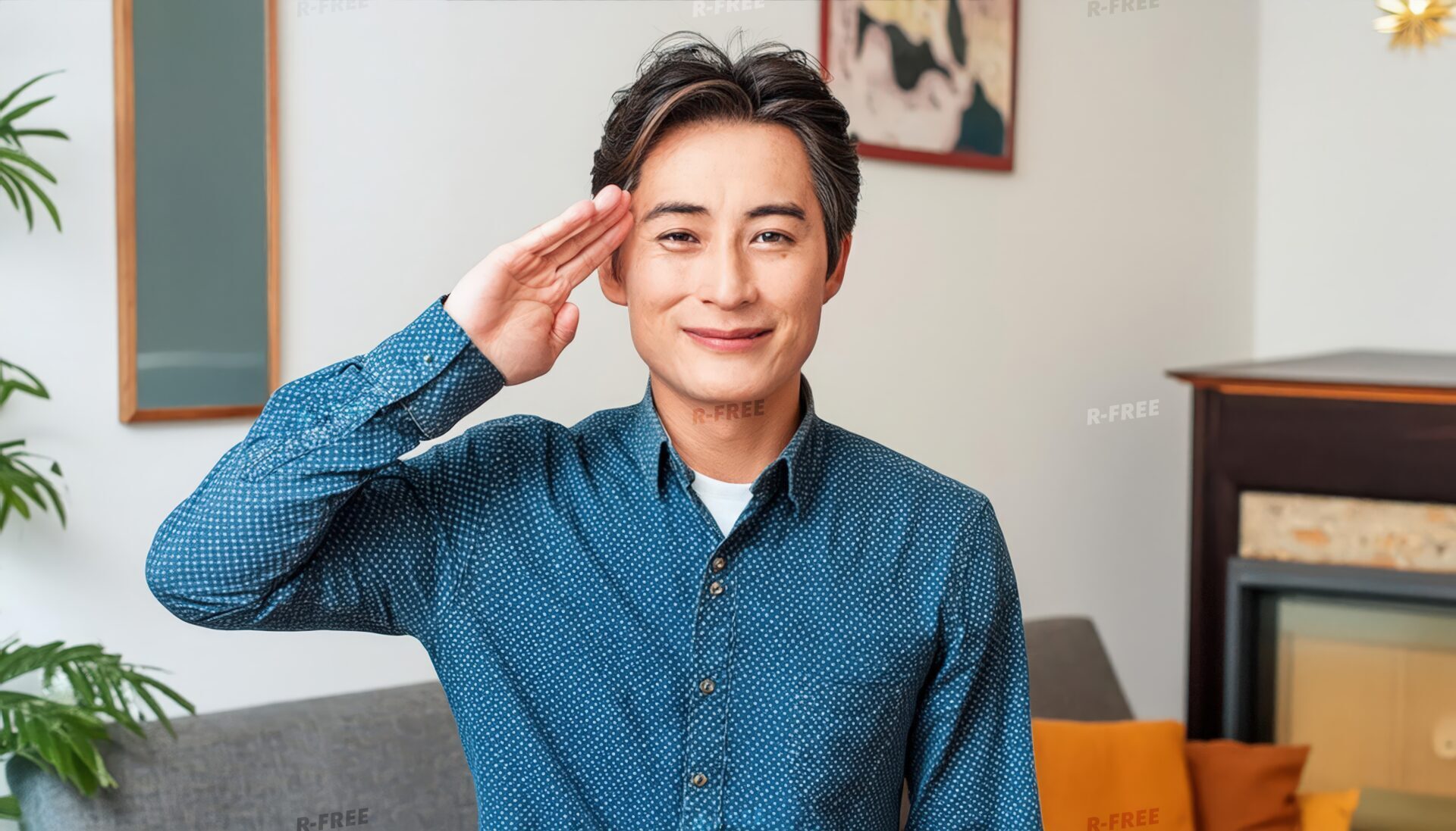 暖炉のあるリビングで笑顔で敬礼する40代男性