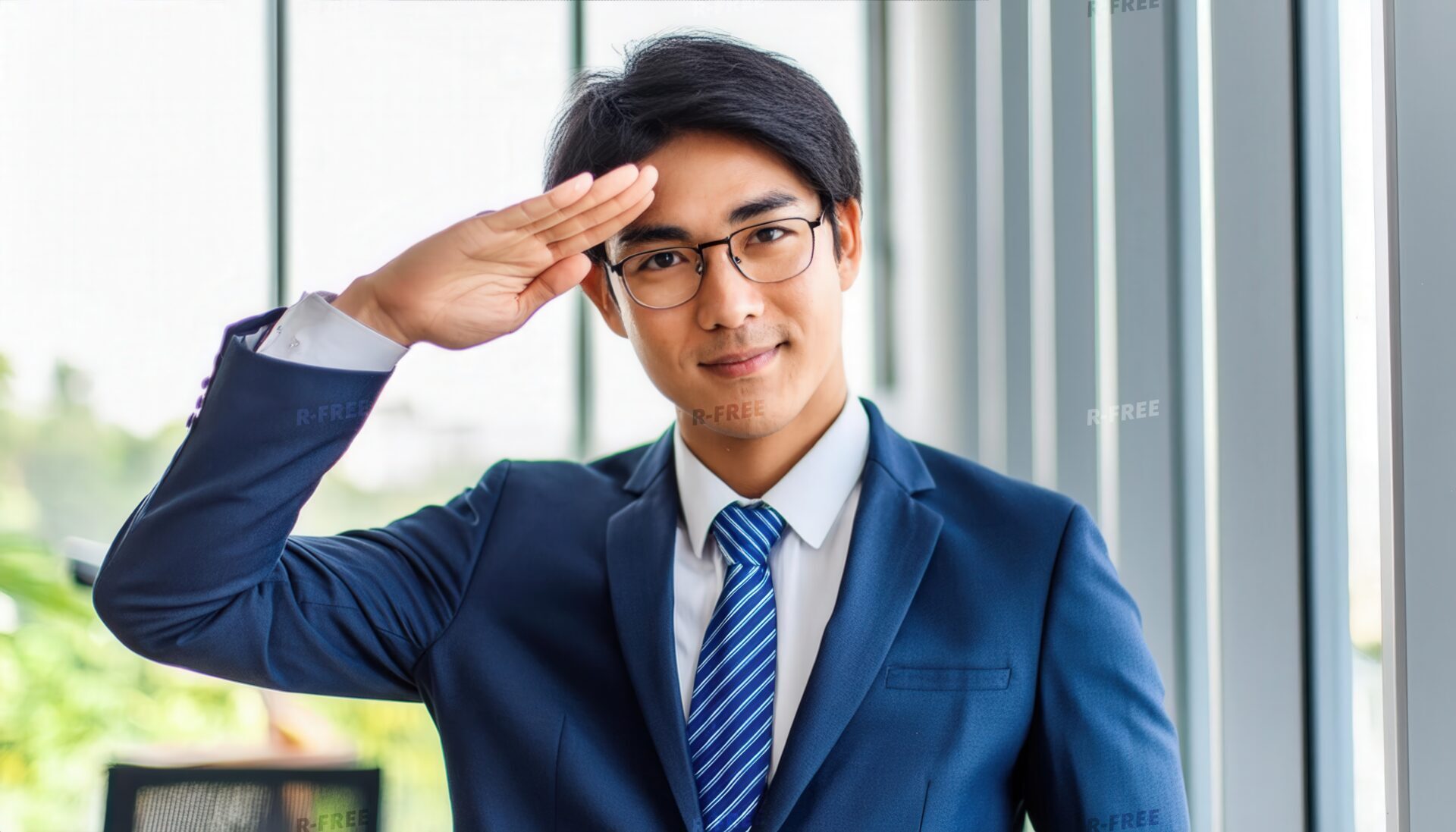 窓辺で敬礼するスーツ姿の人物の笑顔とメガネ