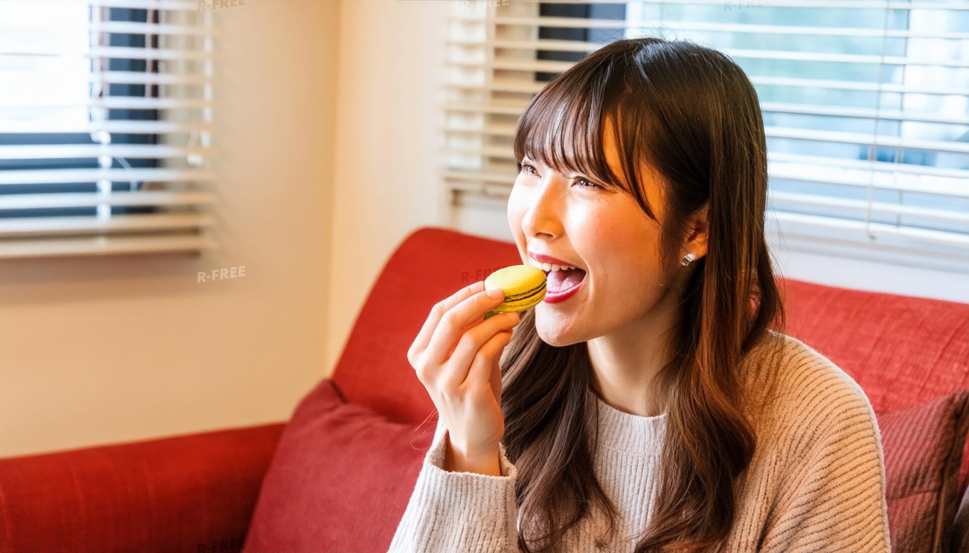 部屋でマカロンを食べる女性
