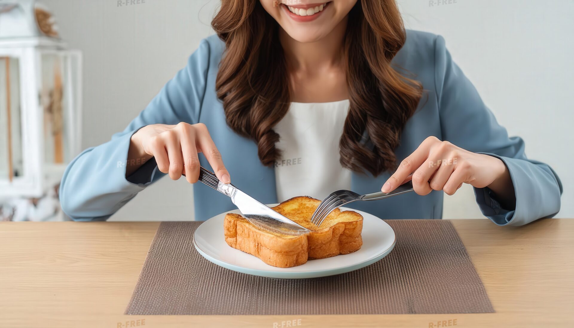 微笑みながらフレンチトーストを切る青いジャケットの女性