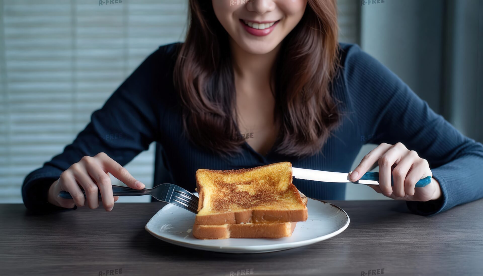 暗色長袖でフレンチトーストを前に微笑む女性