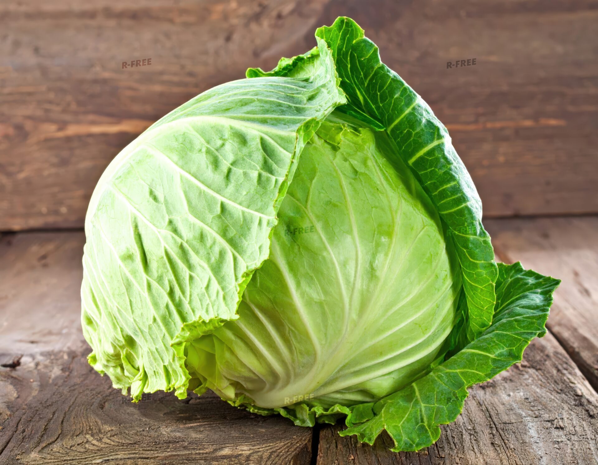 木の板の上に置かれた丸ごとのキャベツ