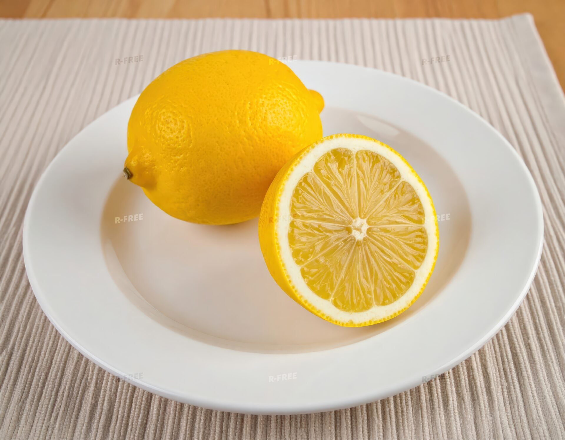 白い皿に盛られた丸ごとのレモンとカットレモンと木目の食卓