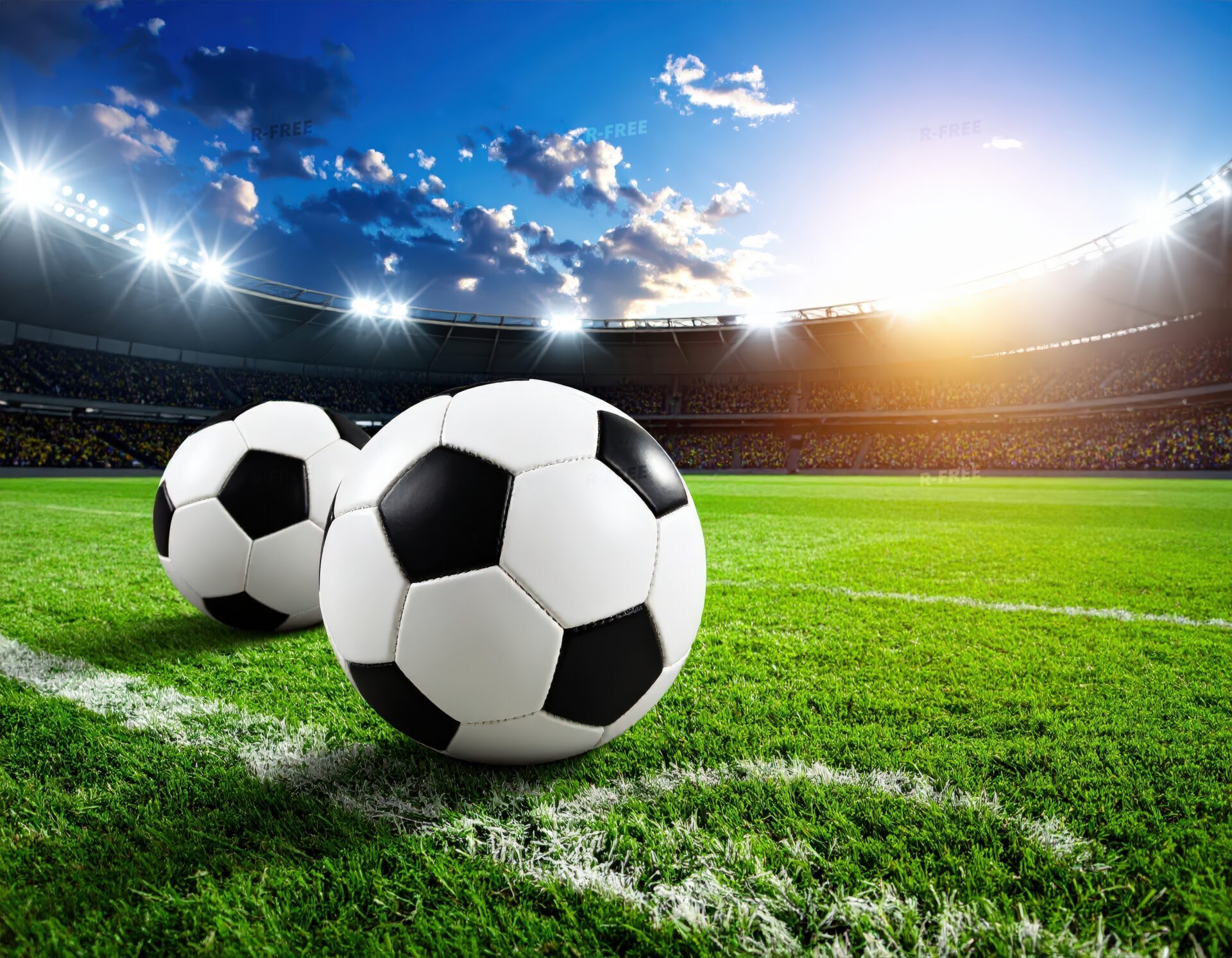 夕暮れのスタジアムに置かれた2つのサッカーボール