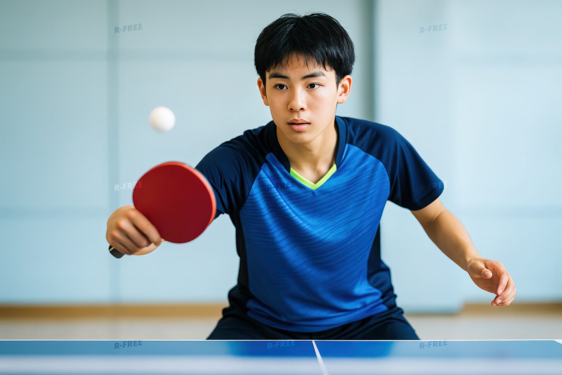 卓球のボールに集中する男子学生
