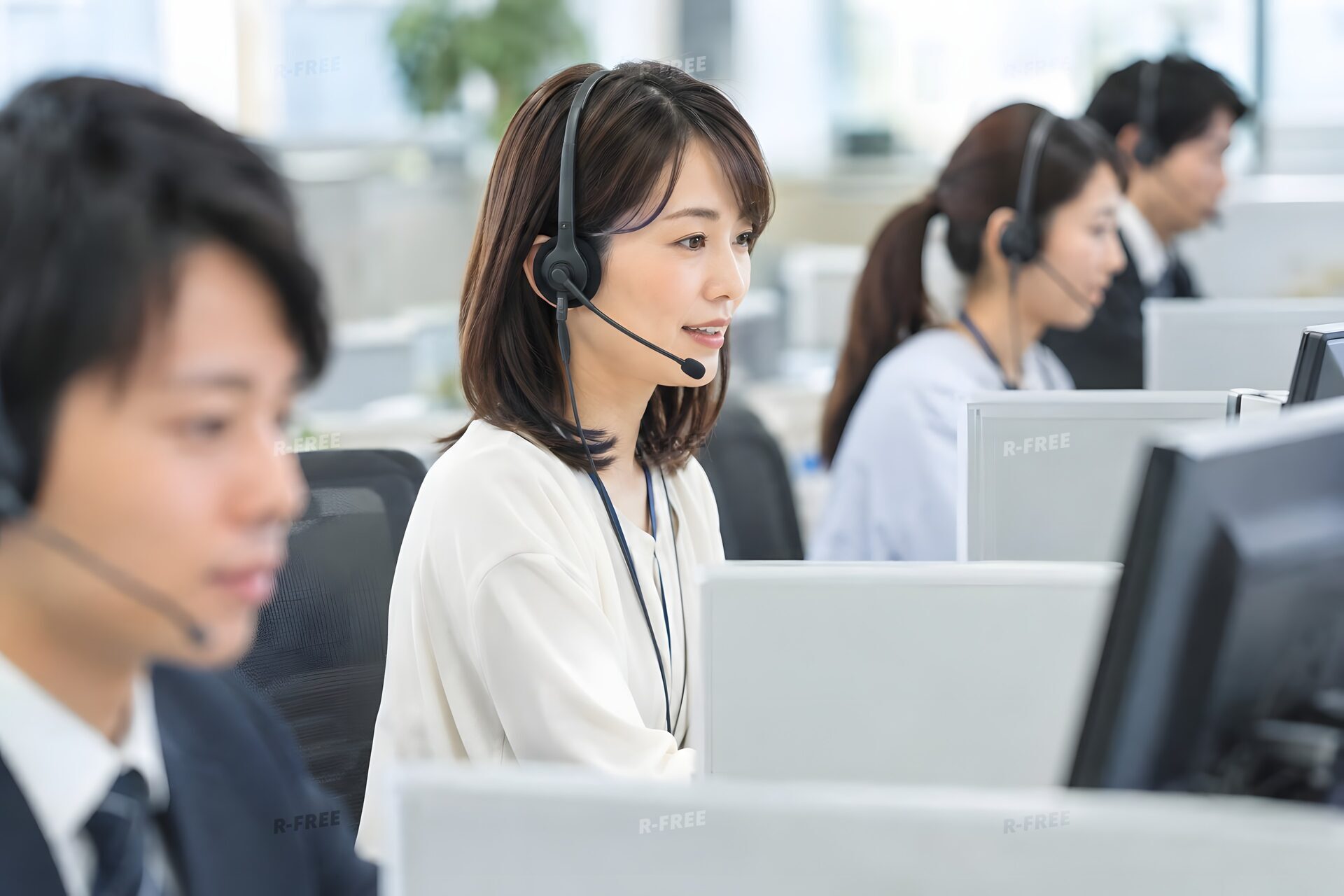 ヘッドセットで応対するコールセンターの女性オペレーター
