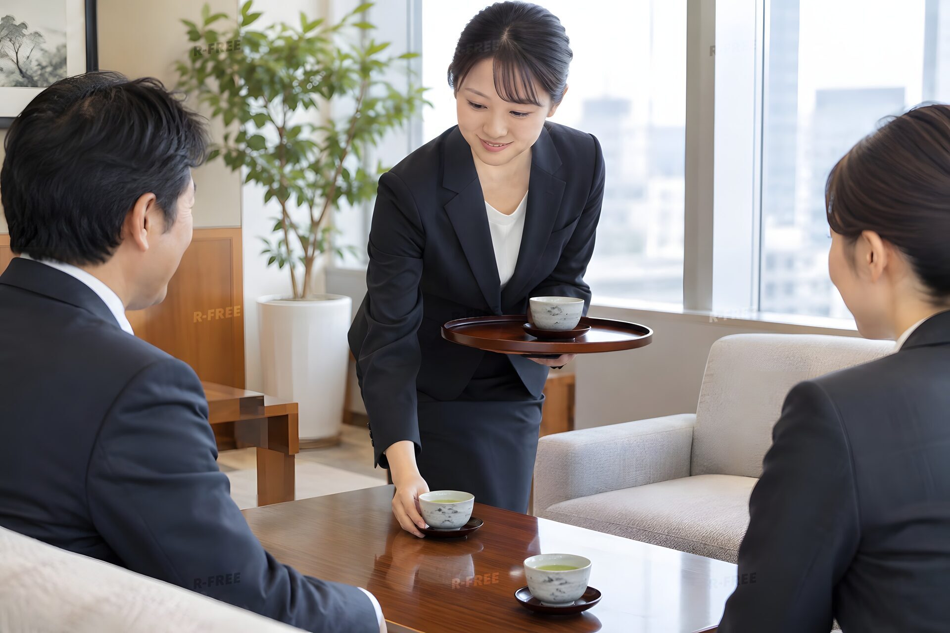 応接室で来客にお茶を出す20代女性