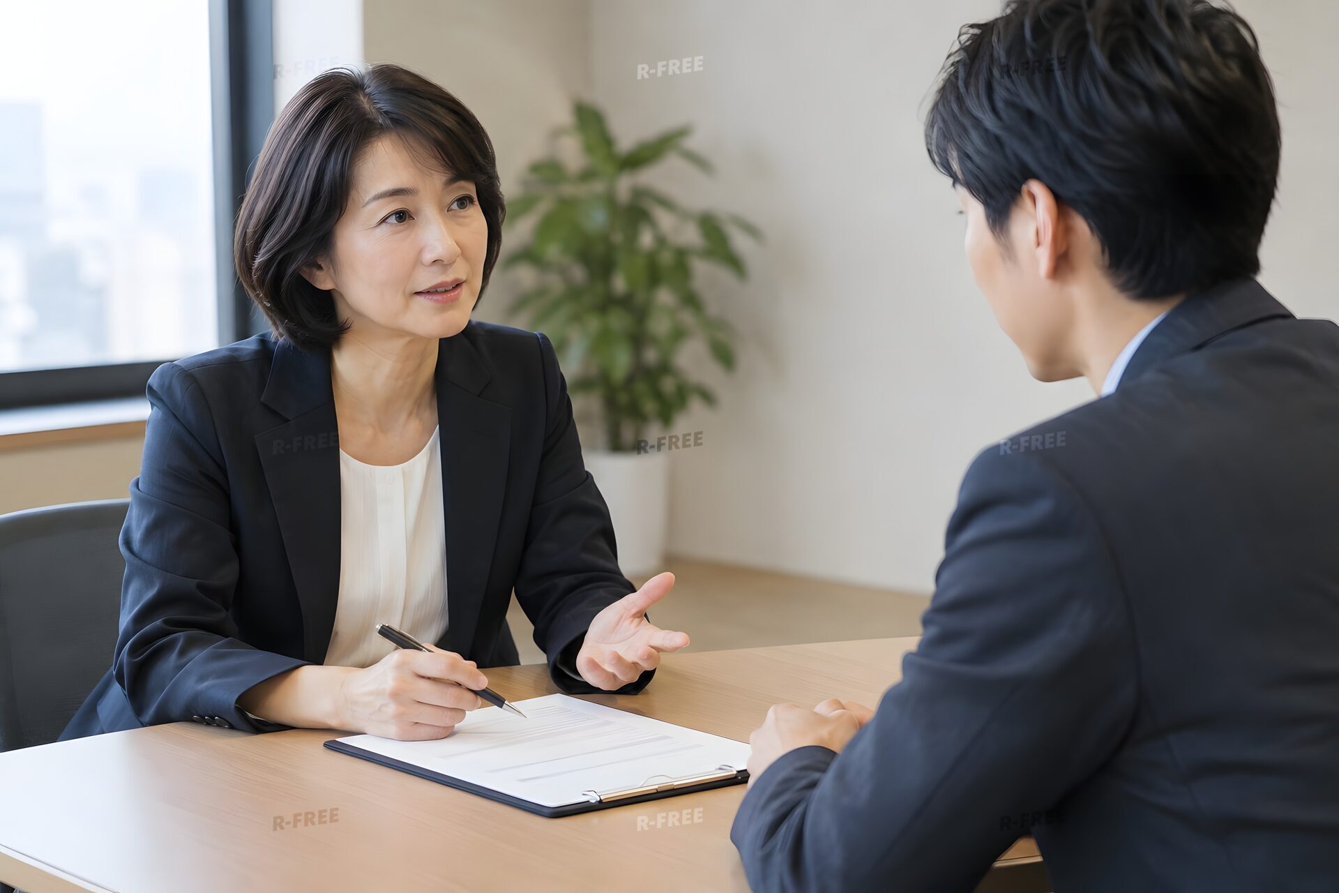 静かな会議室で評価面談をする40代の上司と30代の部下