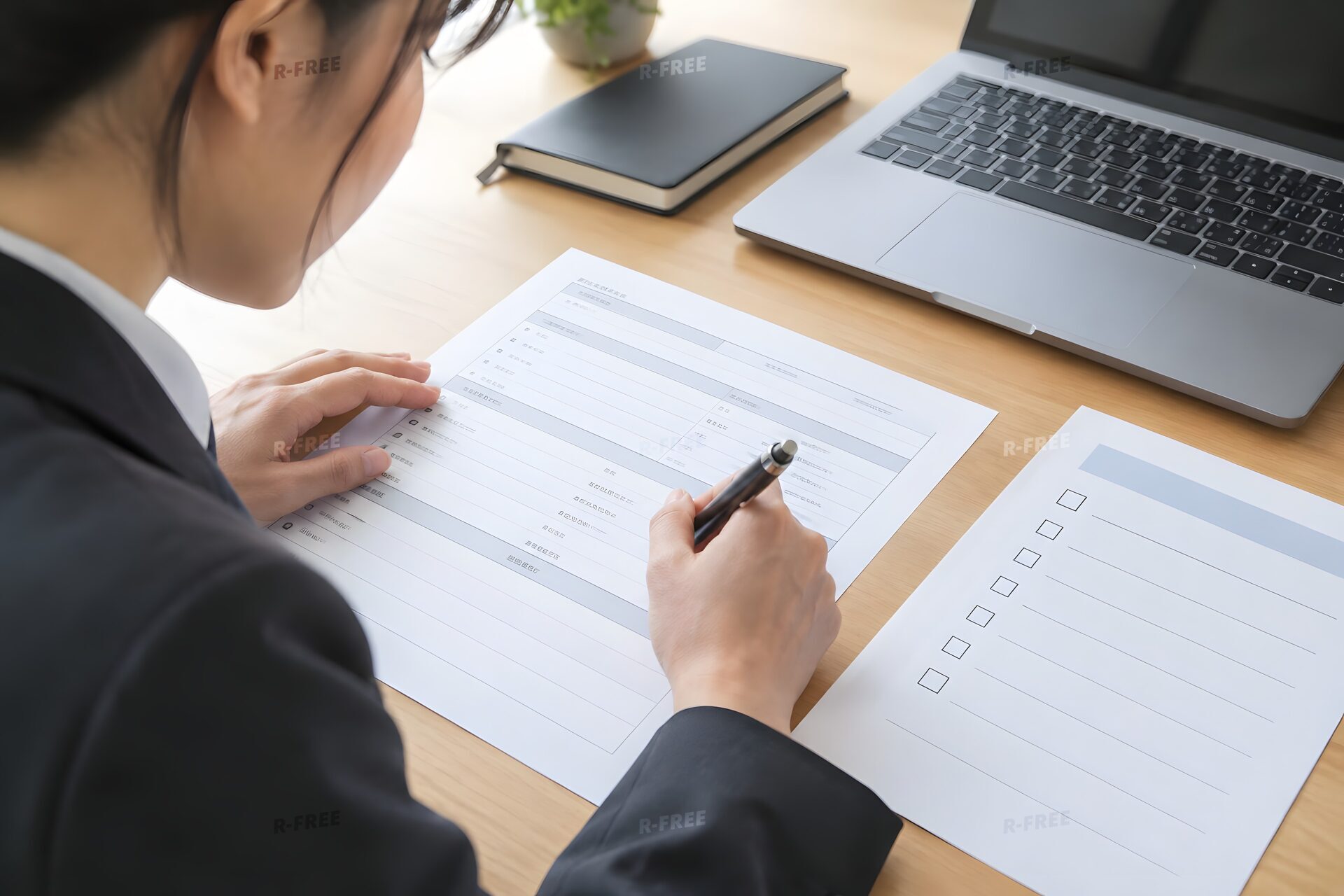 目標シートを見ながら自己評価表に記入する社員の手元