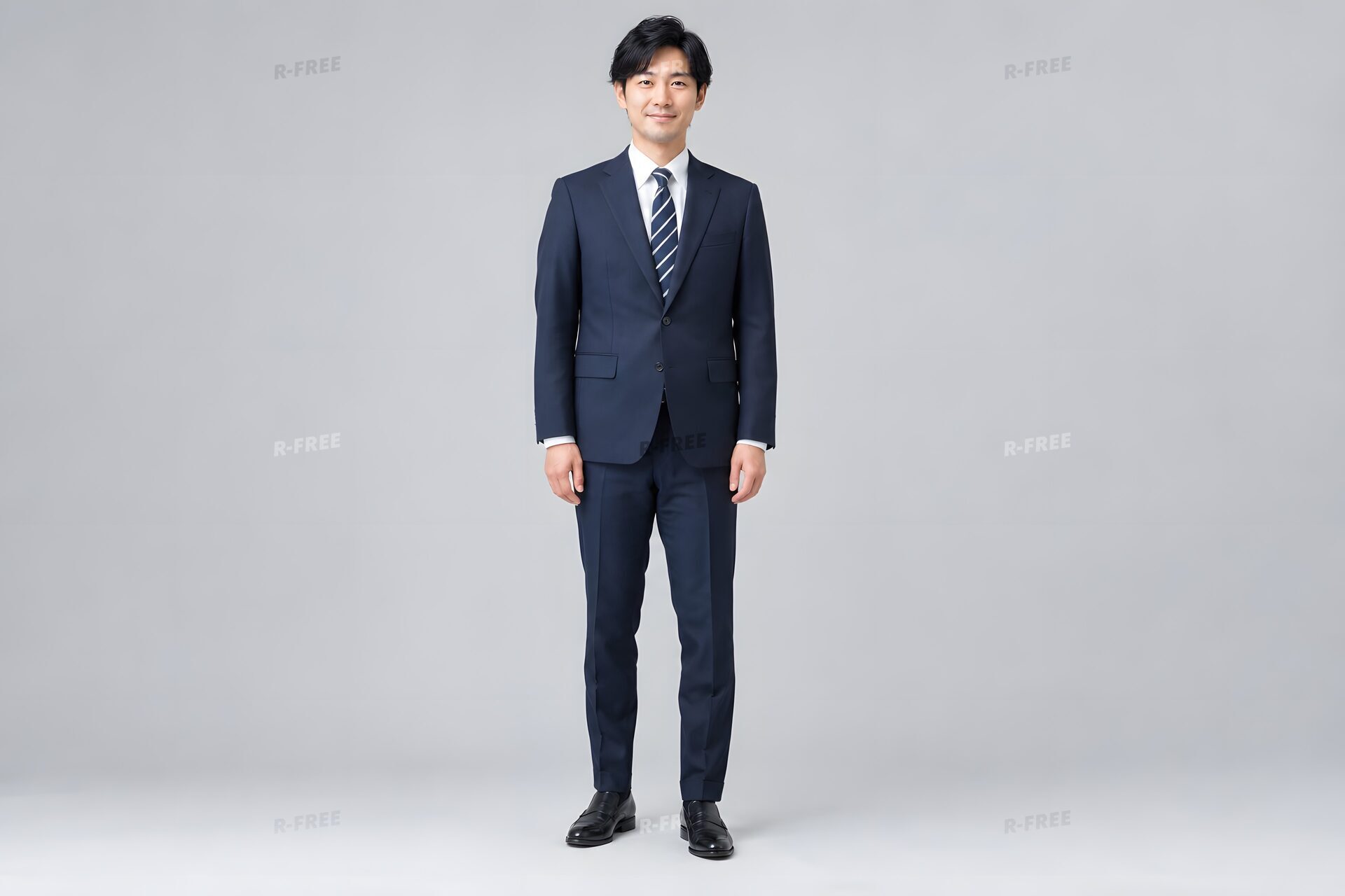 正しい姿勢で立つスーツ姿の30代男性の全身