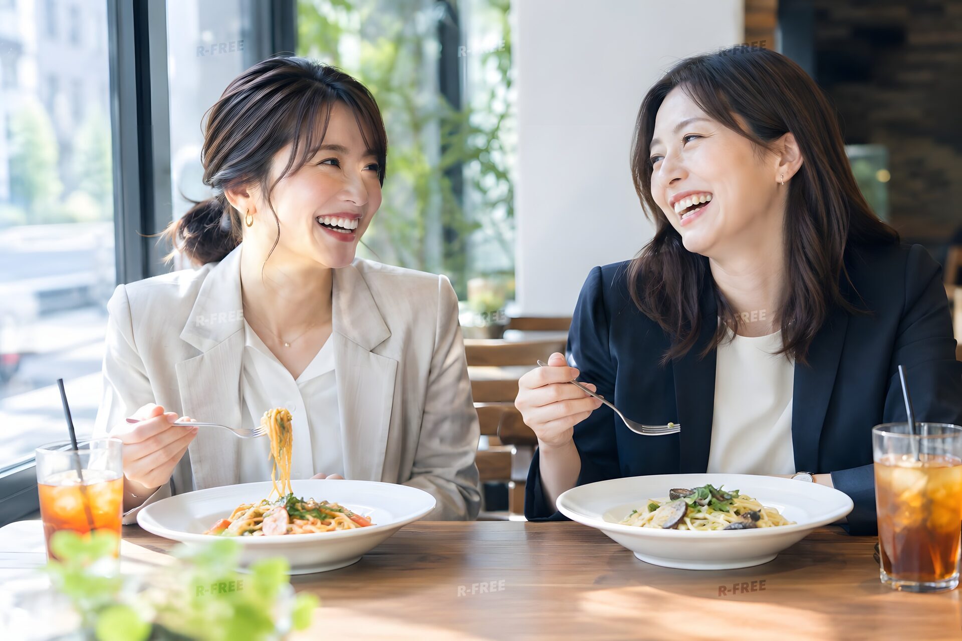 オフィス近くのカフェでランチをとる30代女性2人