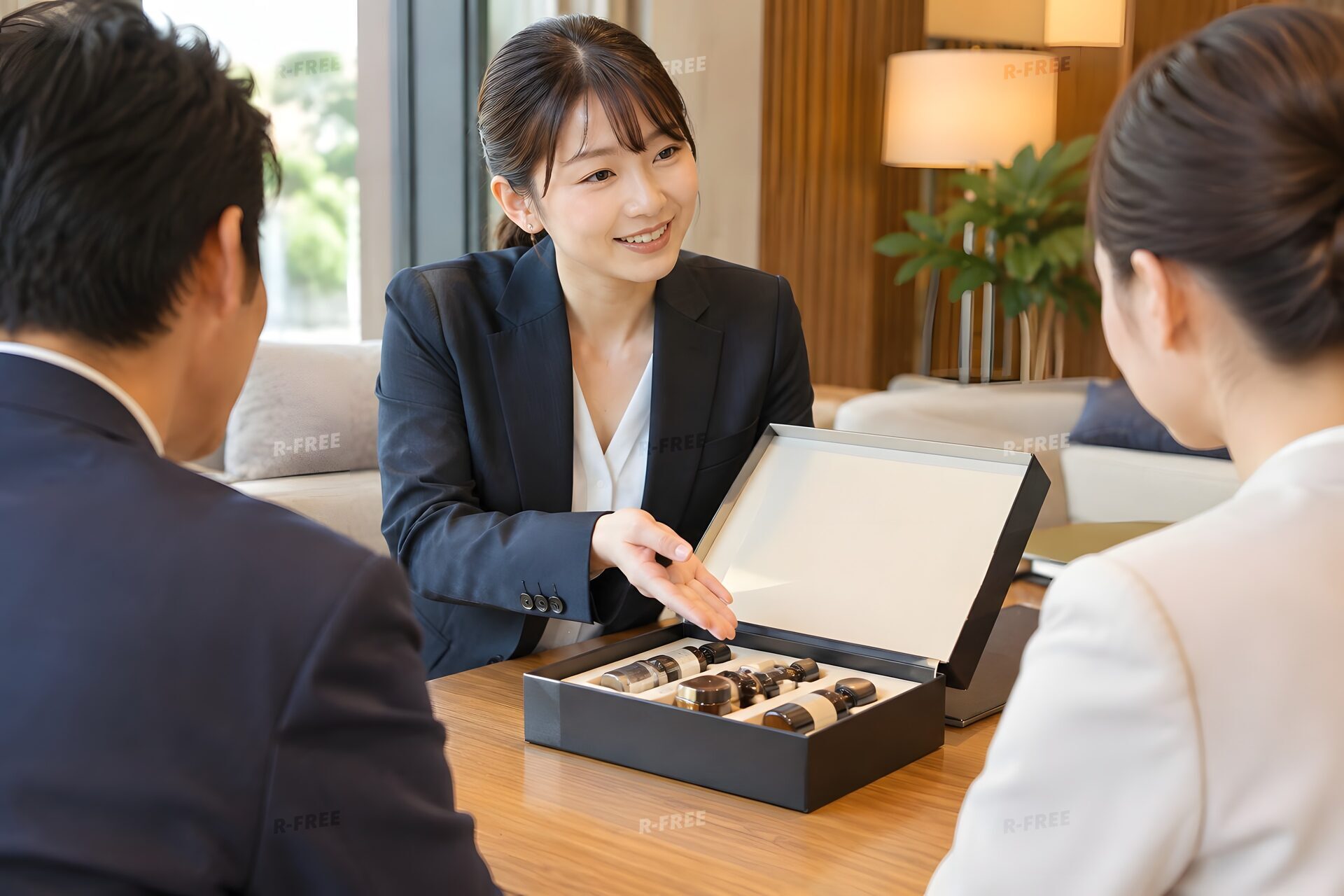 応接室で商品サンプルを見せて提案する30代の営業女性