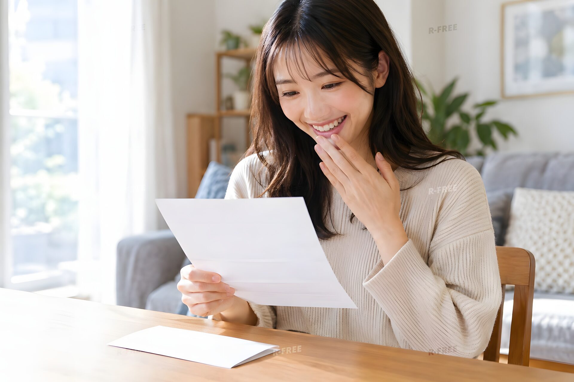 自宅で内定通知書を読んで安堵の笑顔を見せる20代女性