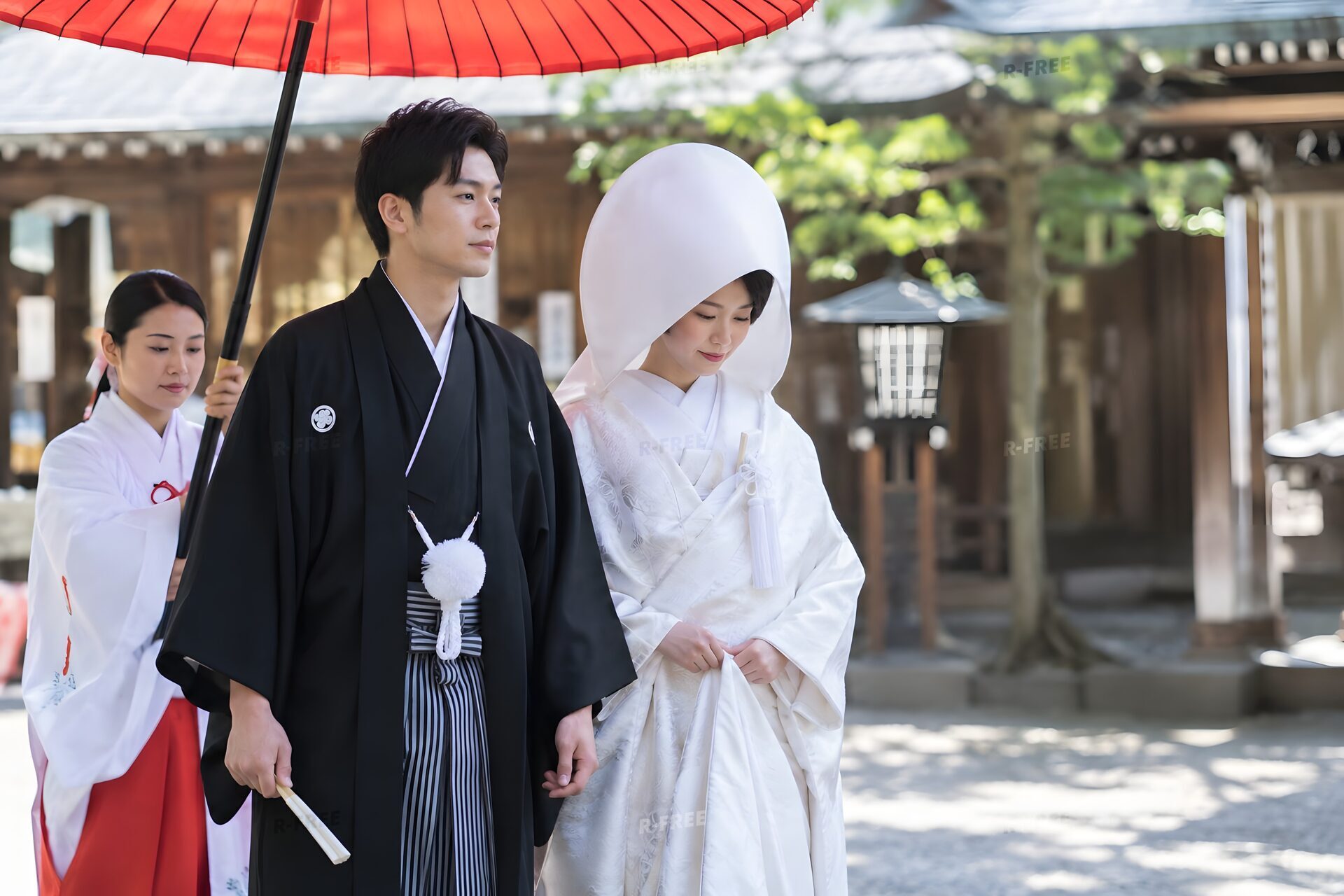 神社で白無垢と紋付袴の新郎新婦が番傘の下を歩く和婚