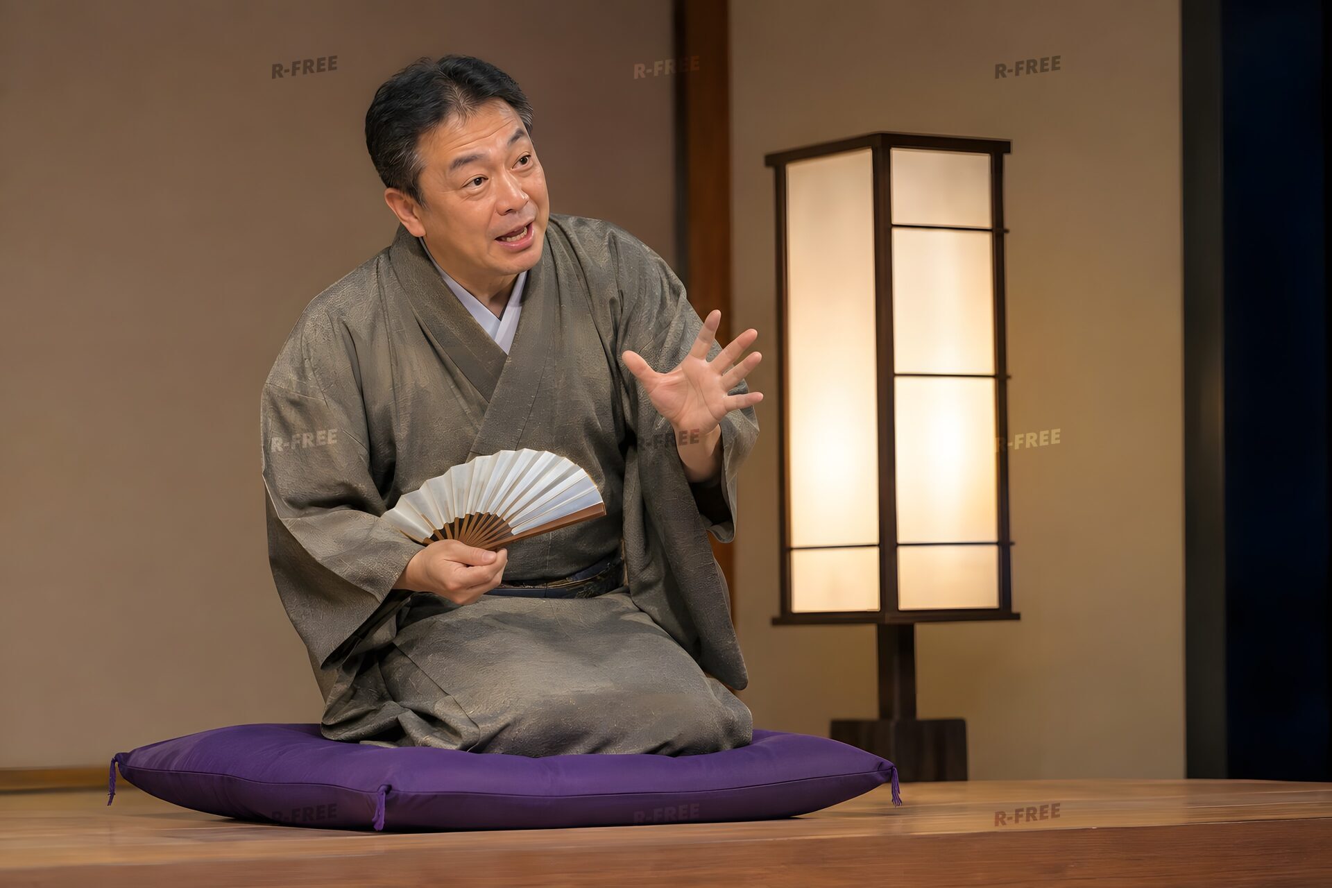 高座で扇子を手に語る50代の落語家
