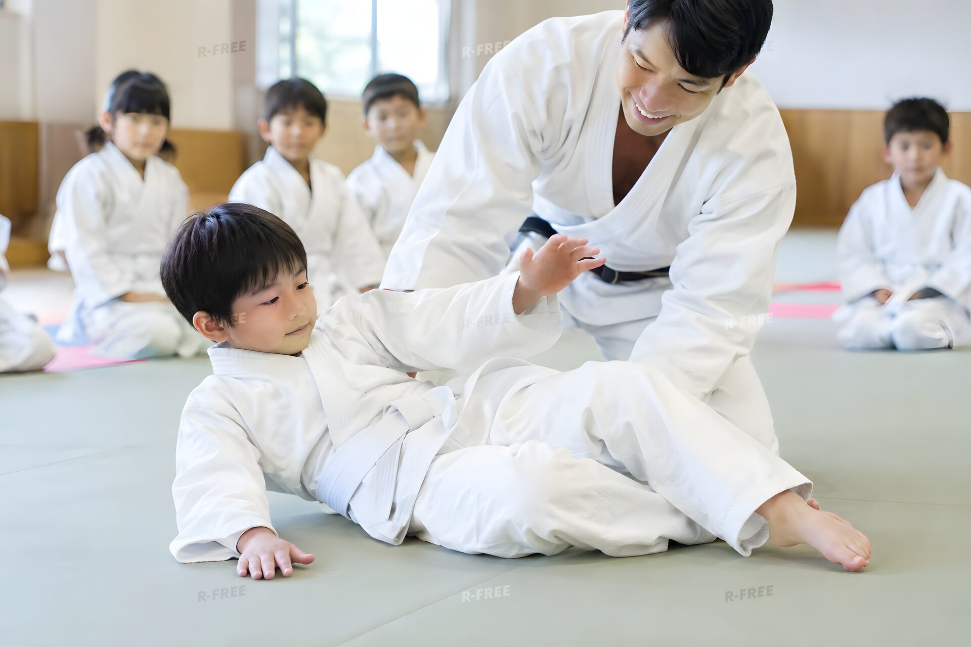 子ども柔道教室で受け身を教わる8歳くらいの男の子