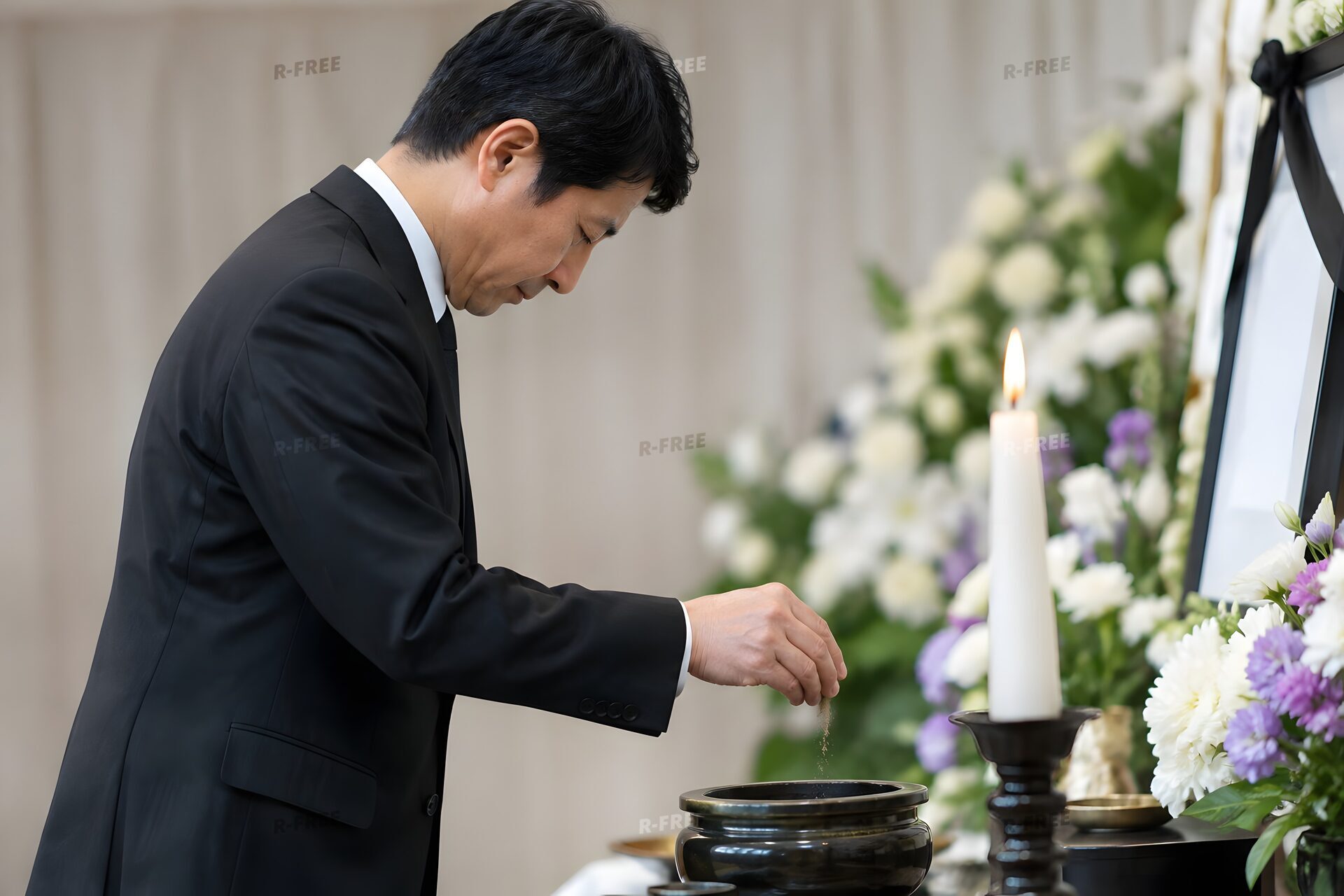 葬儀で焼香をする喪服の40代男性