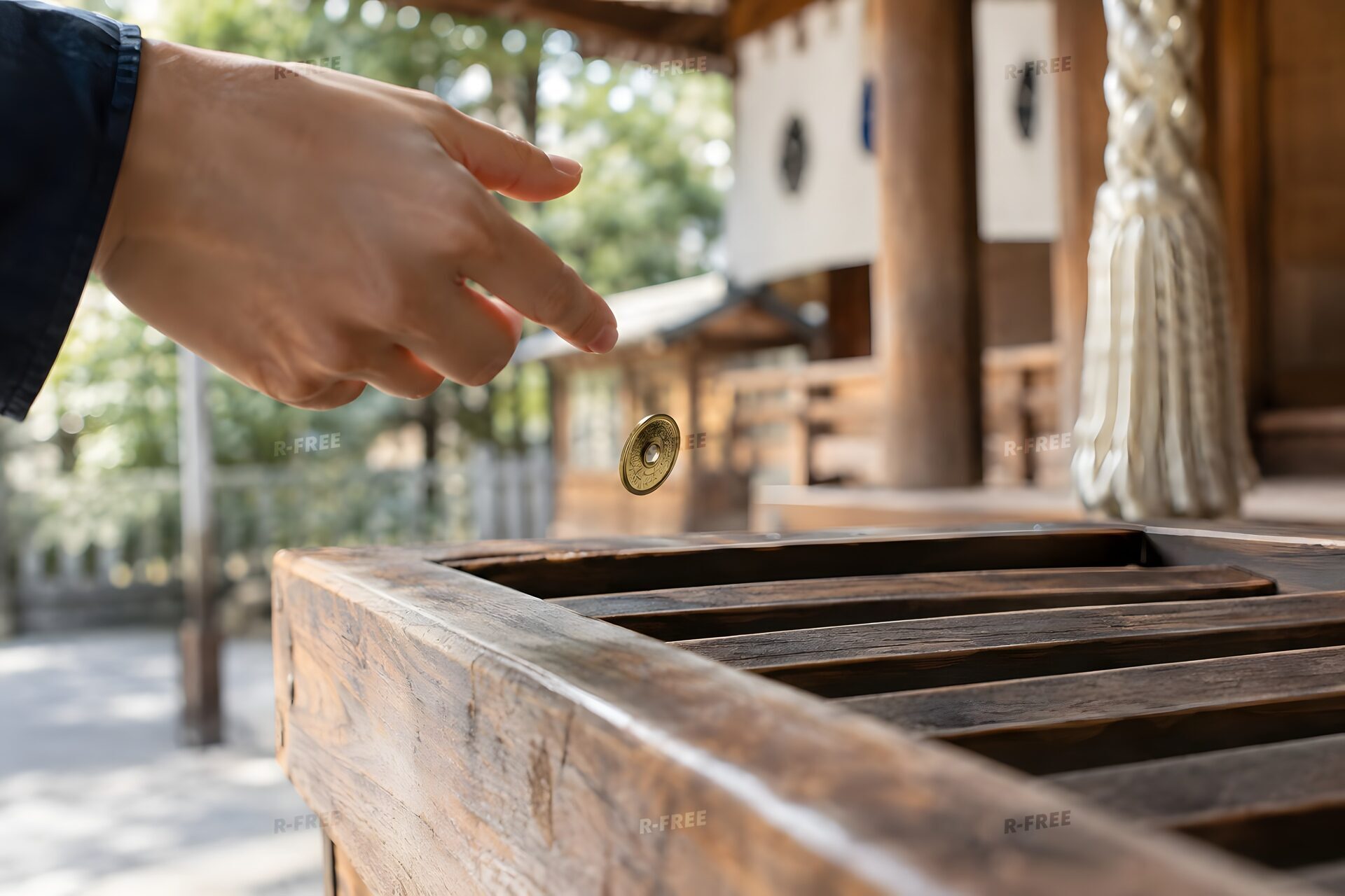 賽銭箱に五円玉を投げ入れる手元