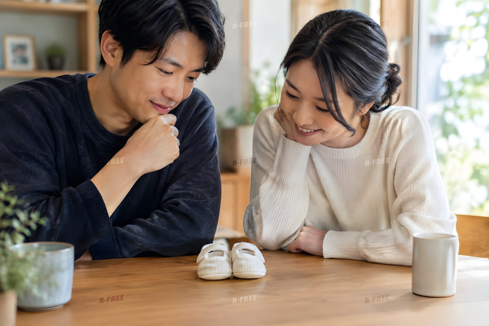 ベビーシューズを前に将来を話し合う30代夫婦