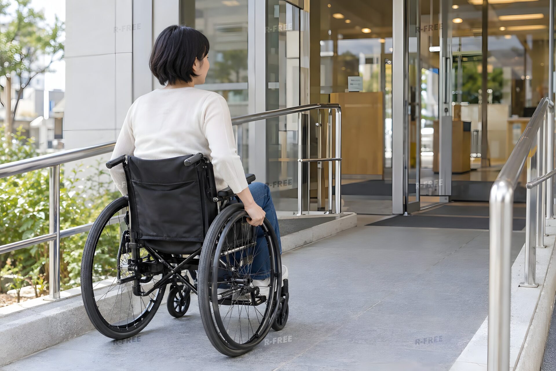 スロープを上って建物に入る車いすの女性