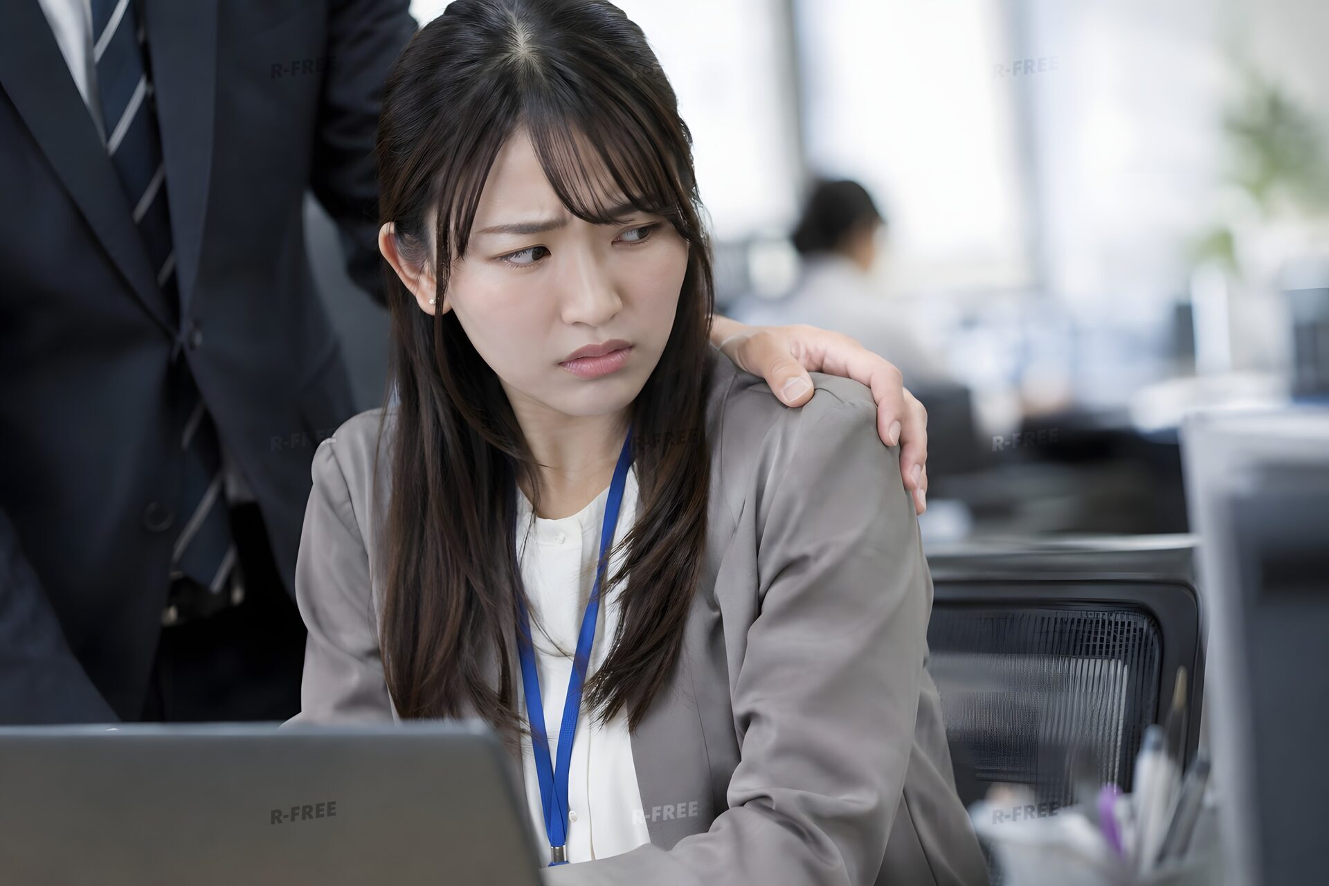 肩に手を置かれて困惑する女性社員（セクハラ）