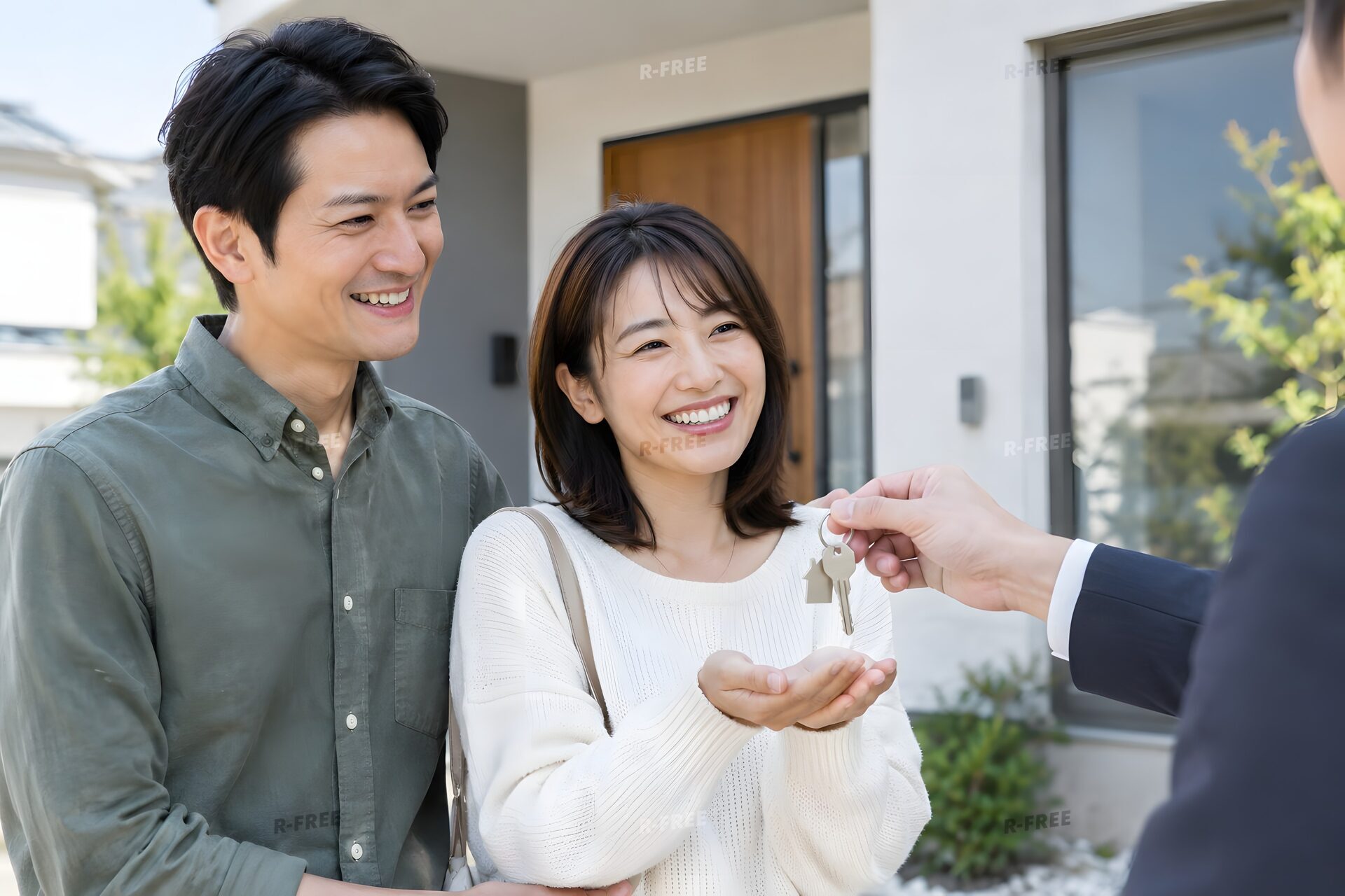 新居の前で鍵を受け取る夫婦