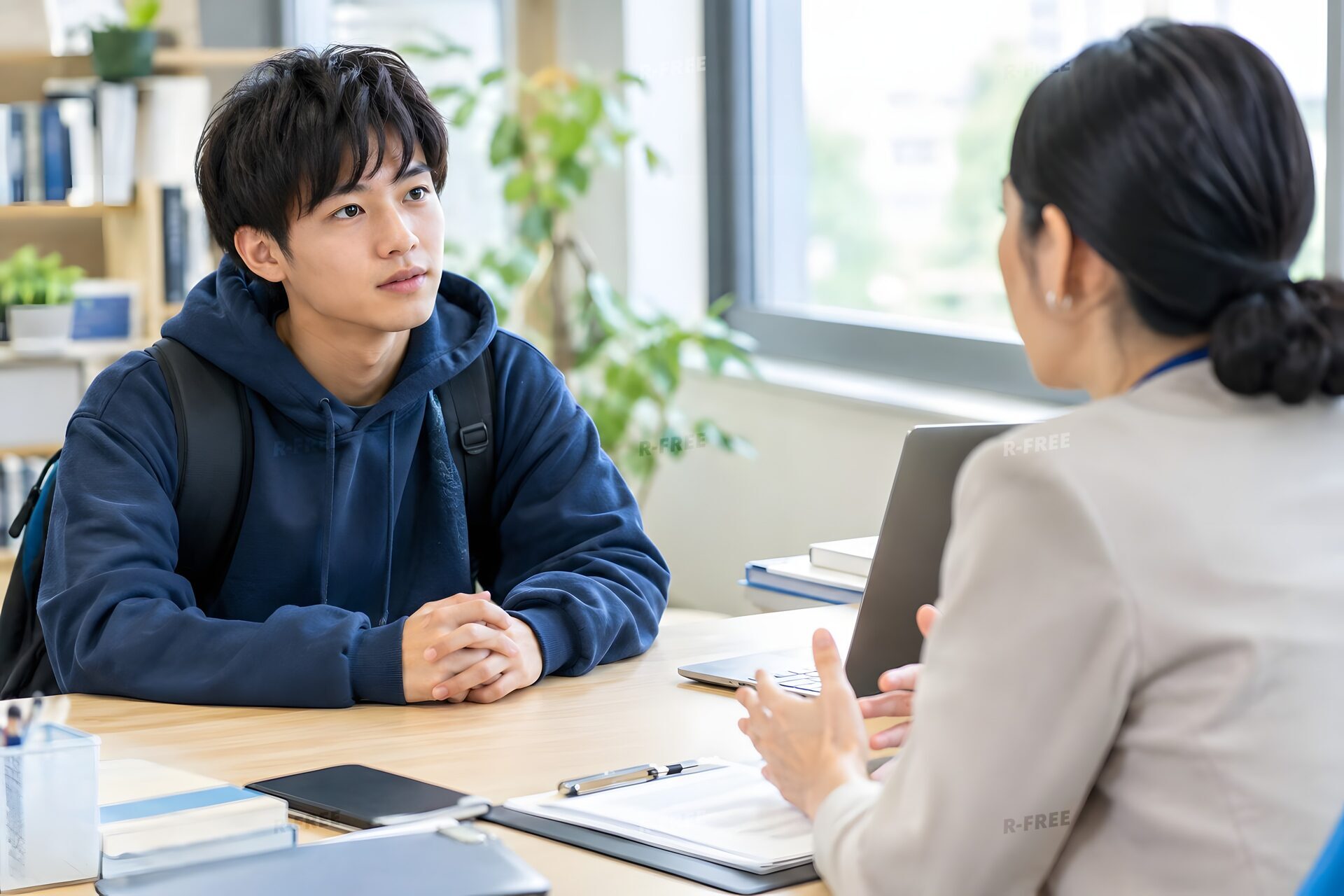 大学の窓口で奨学金を相談する男子学生