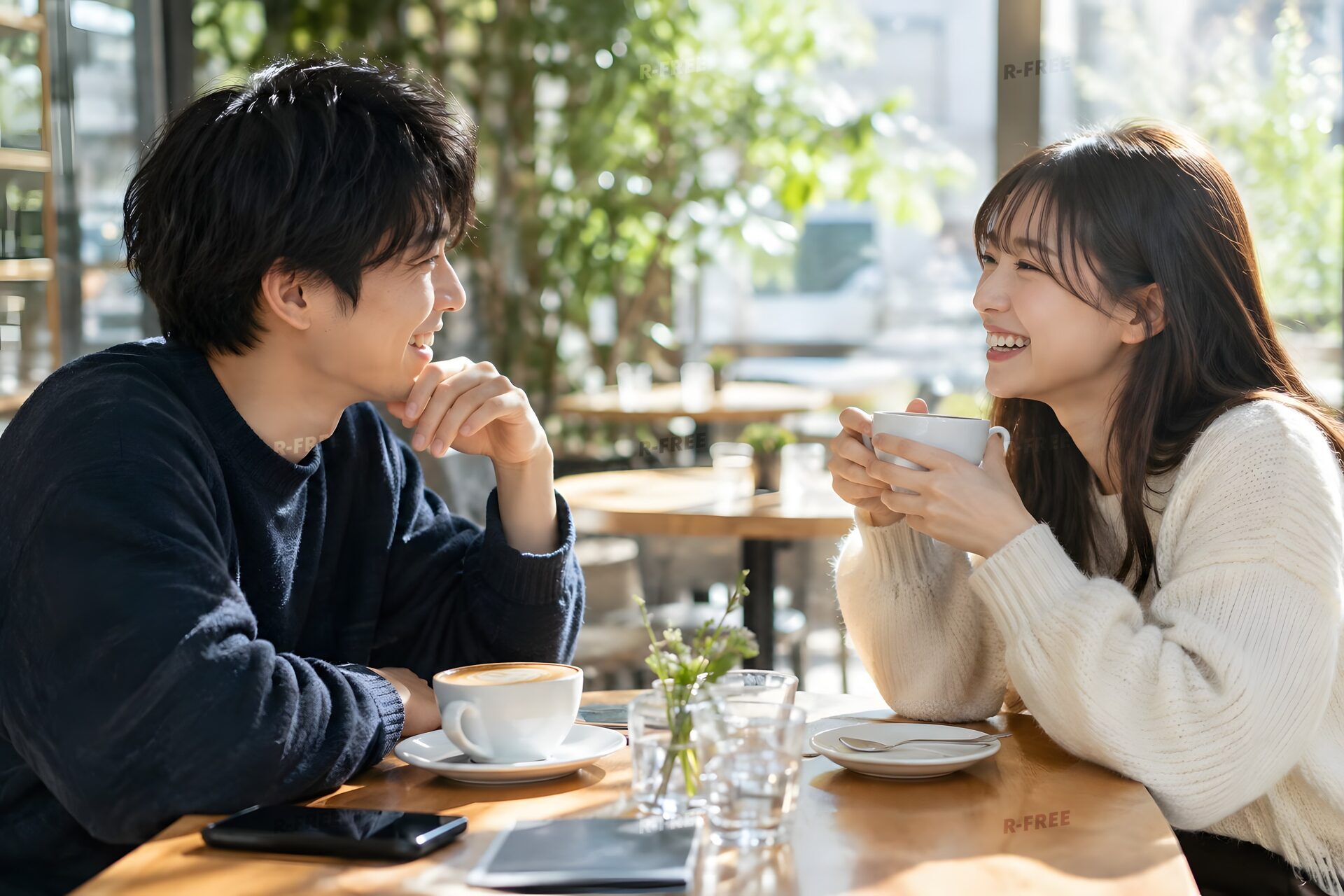カフェで笑い合う20代のカップル