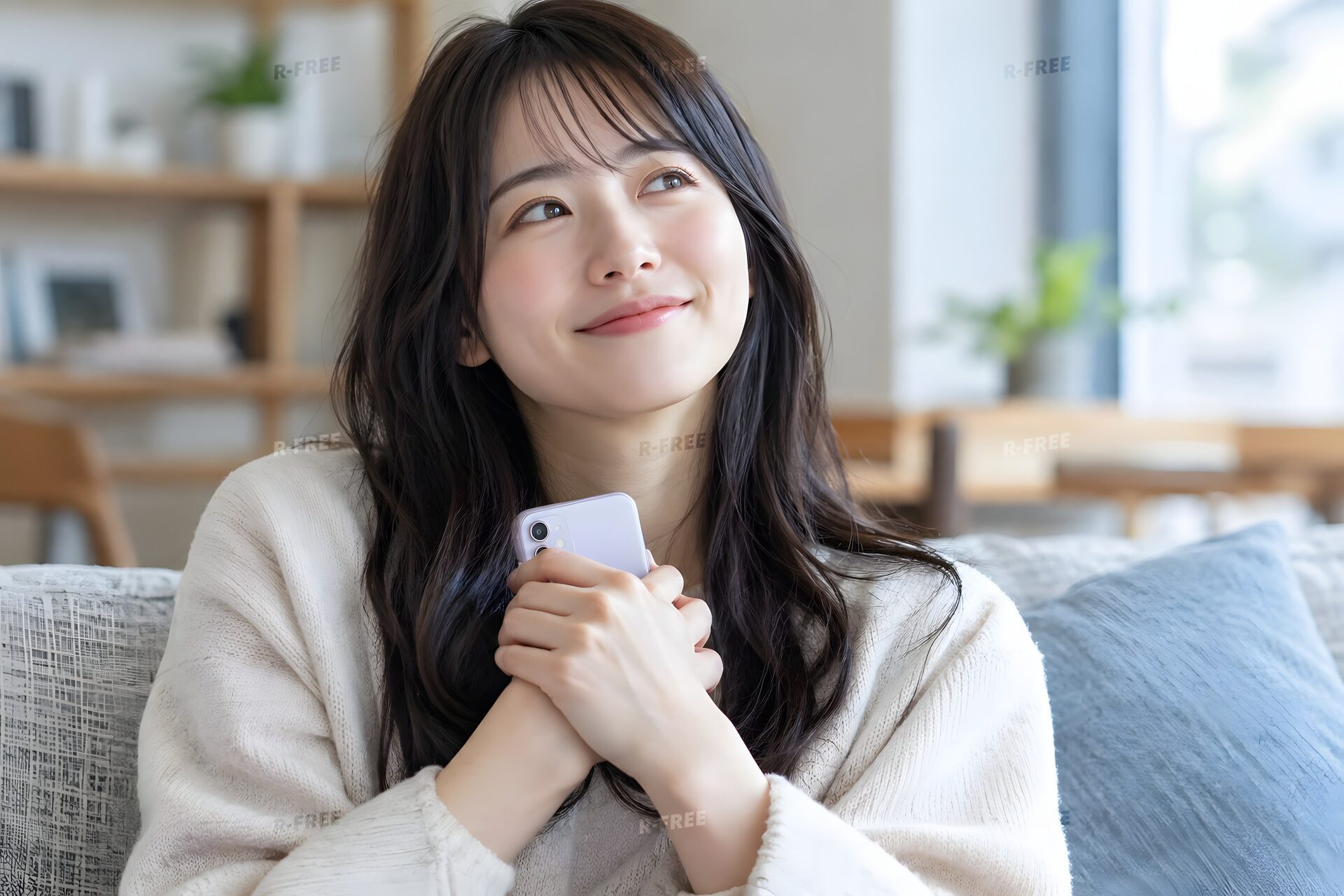 スマホを胸に当てて微笑む20代女性