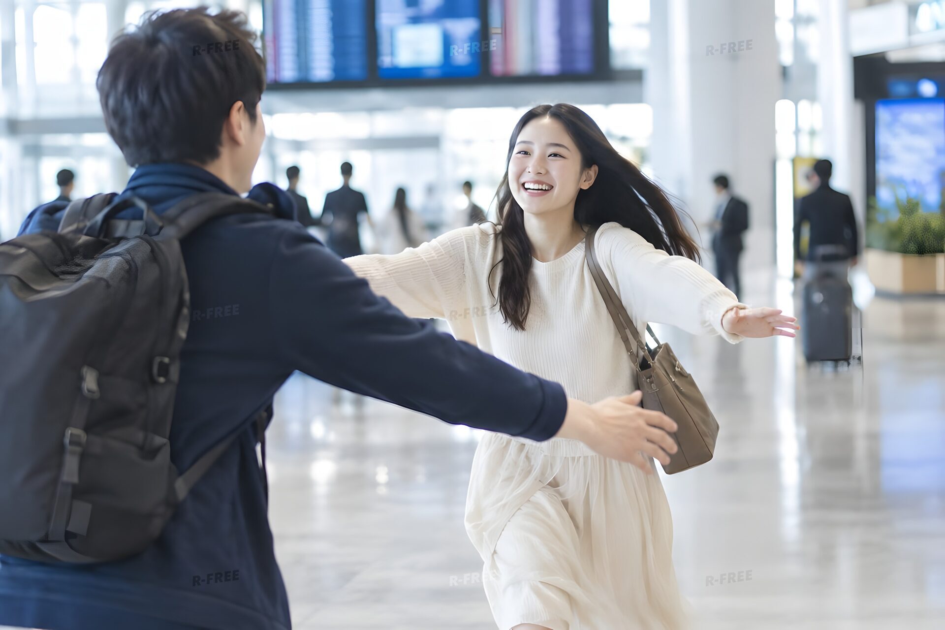 空港で再会を喜ぶカップル