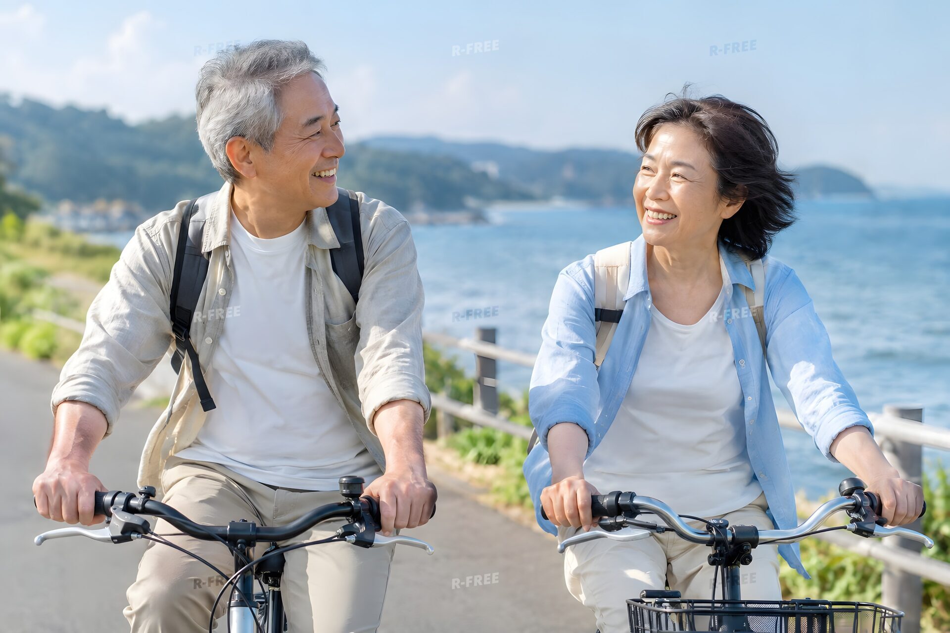 海沿いを並んでサイクリングする熟年夫婦