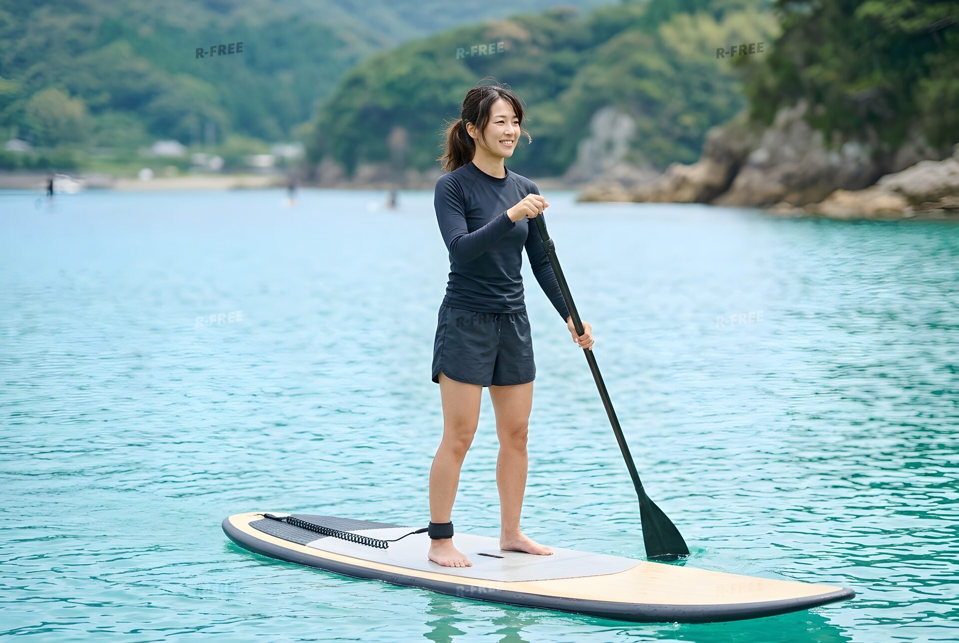 パドルボードで海を進む女性