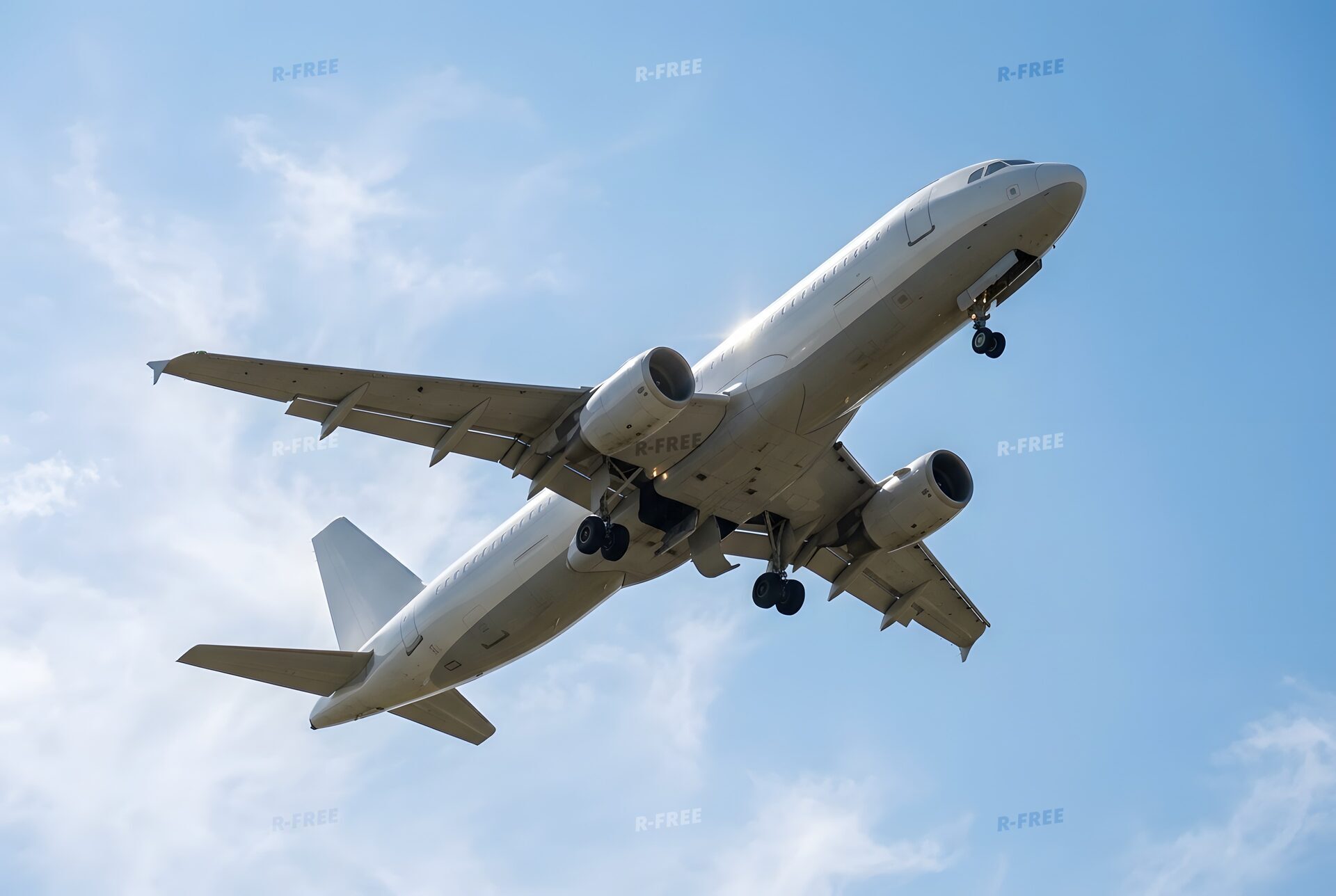 青空へ上昇する離陸直後の旅客機