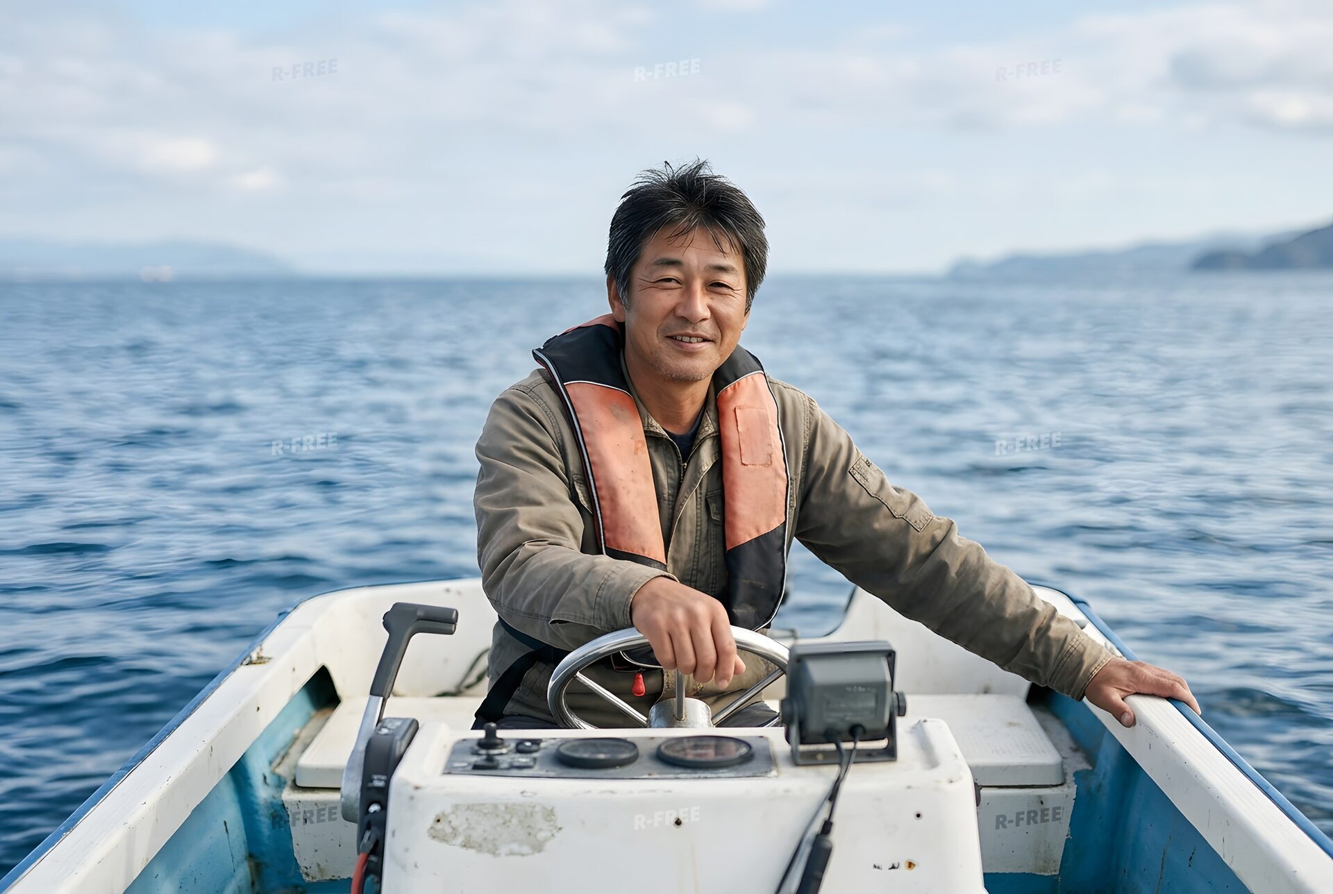 救命胴衣をつけてボートを操縦する男性