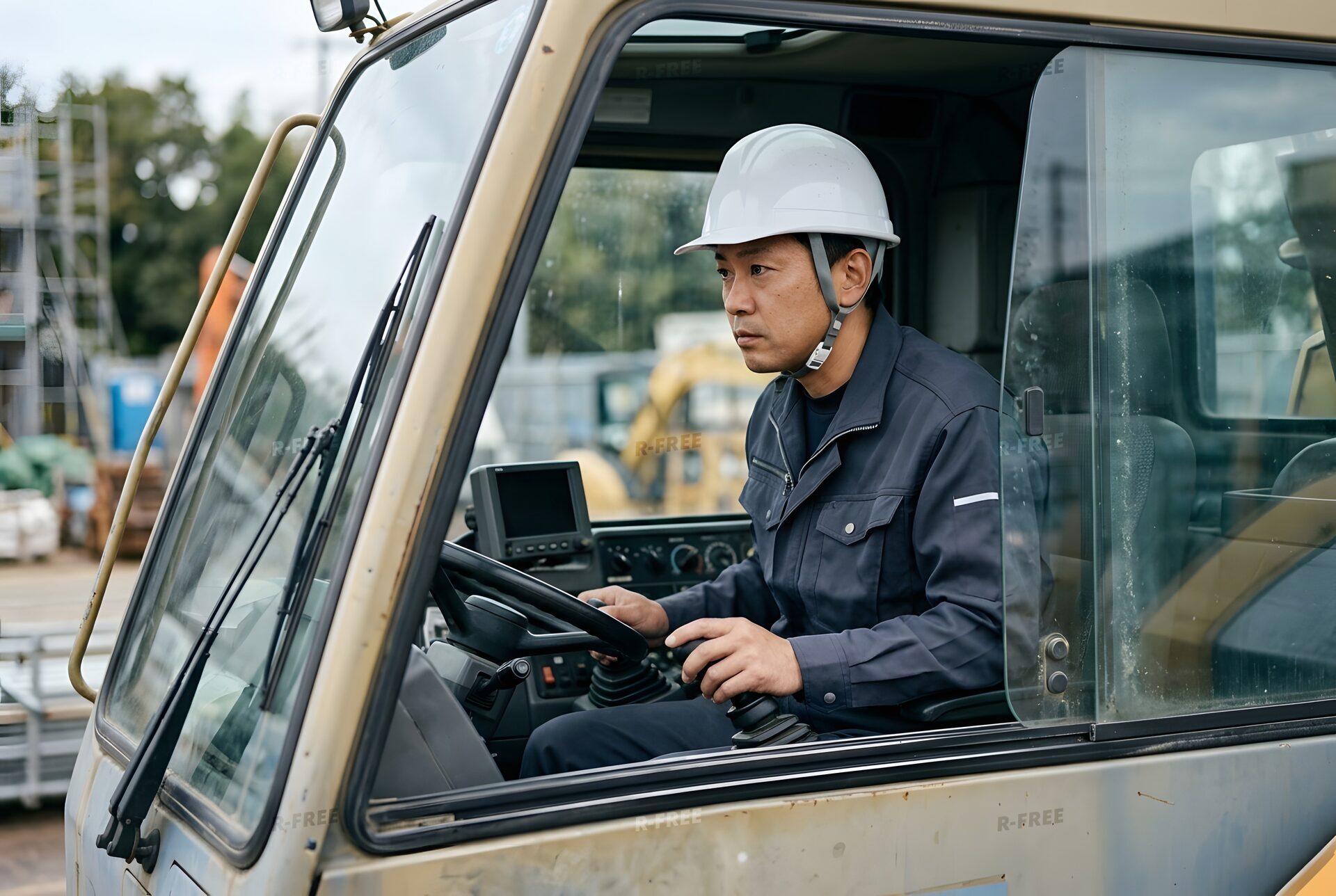 クレーン車の運転席で操作するオペレーター