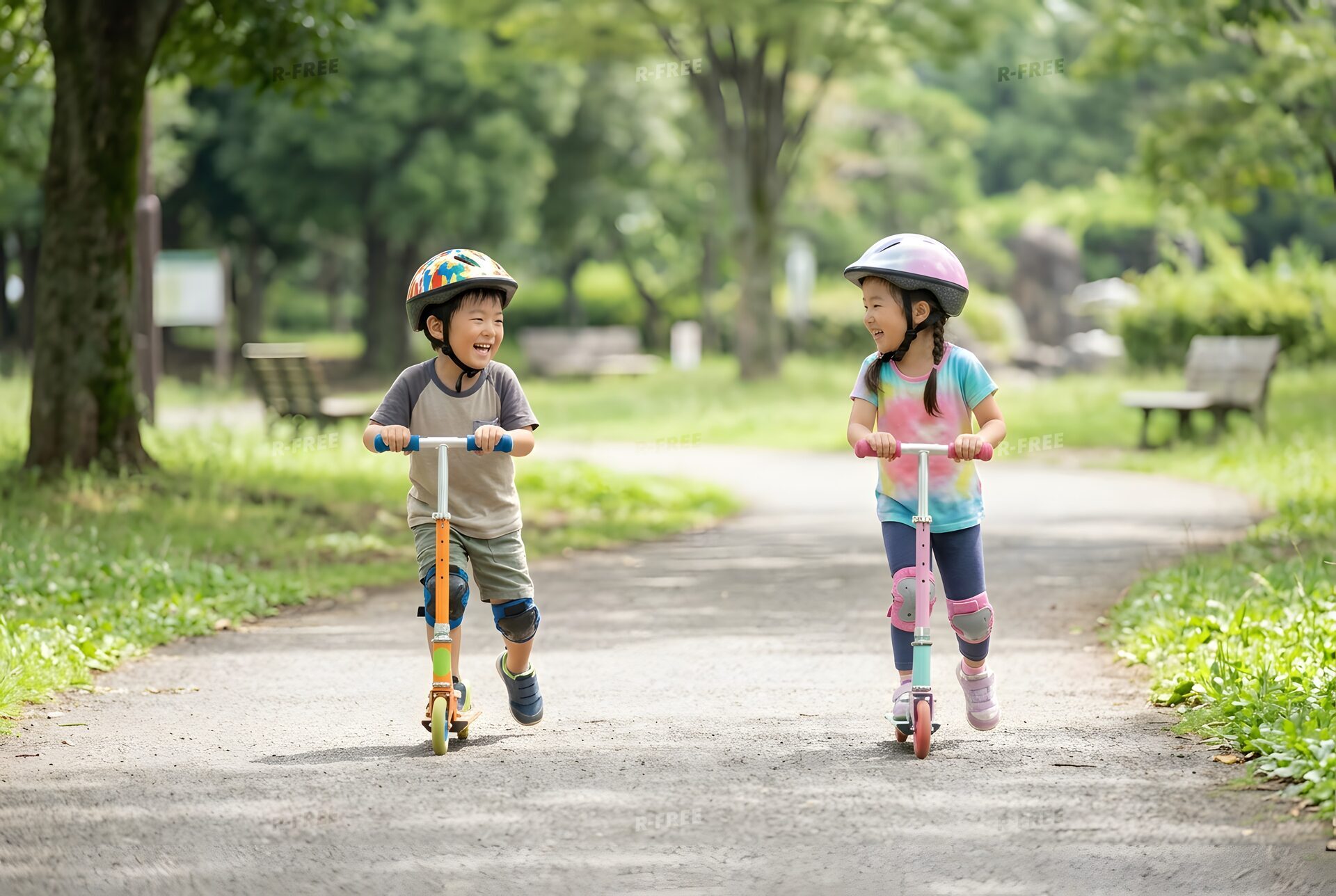 ヘルメットで並んでキックスクーターに乗る子ども